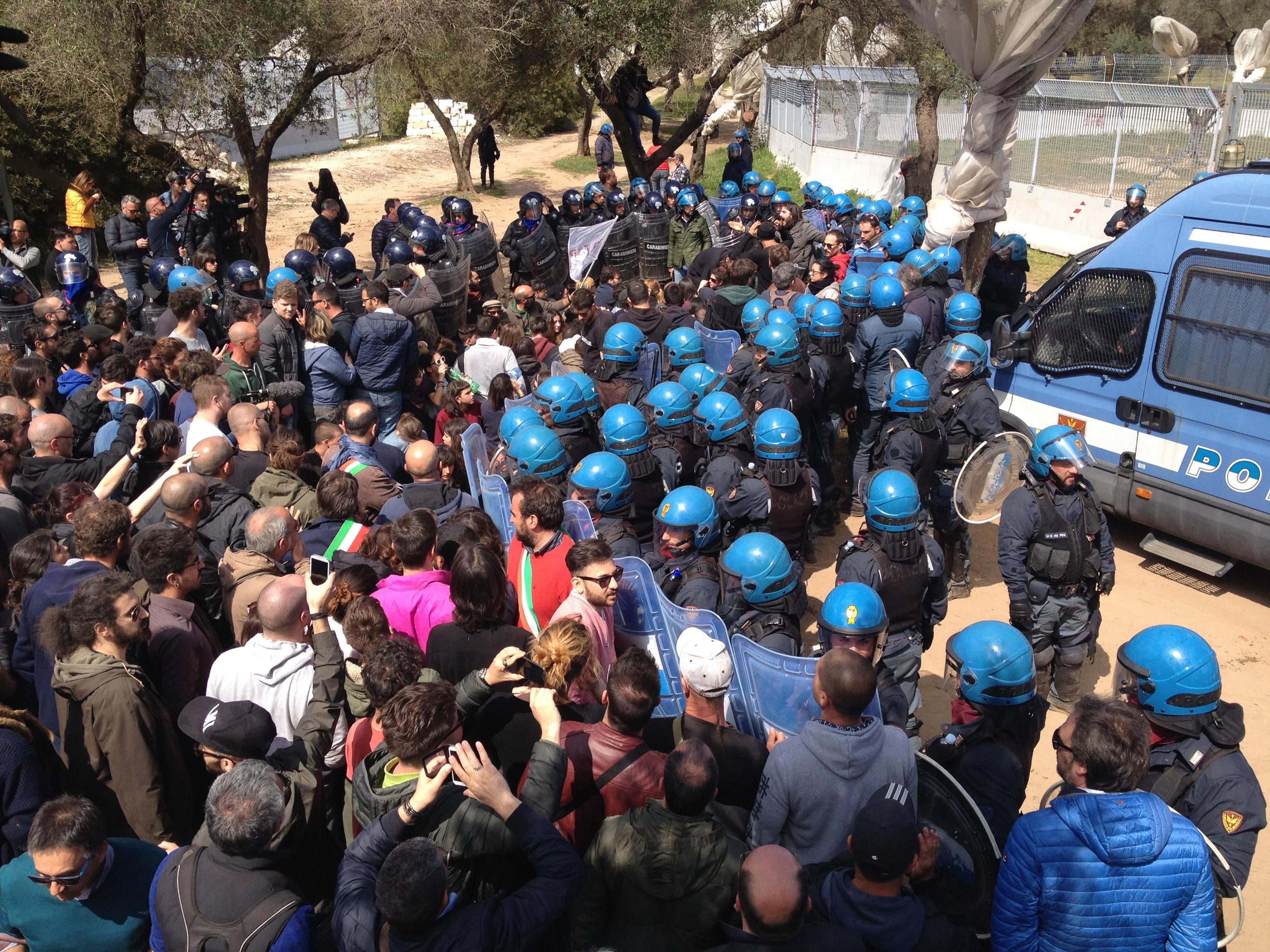 Polizia schierata vicino al cantiere della Tap a Melendugno, in provincia di Lecce, contro i manifestanti che protestano per l'espianto degli ulivi sul tracciato dove dovrebbe sorgere il micro-tunnel del gasdotto, 28 marzo 2017. ANSA / CLAUDIO LONGO