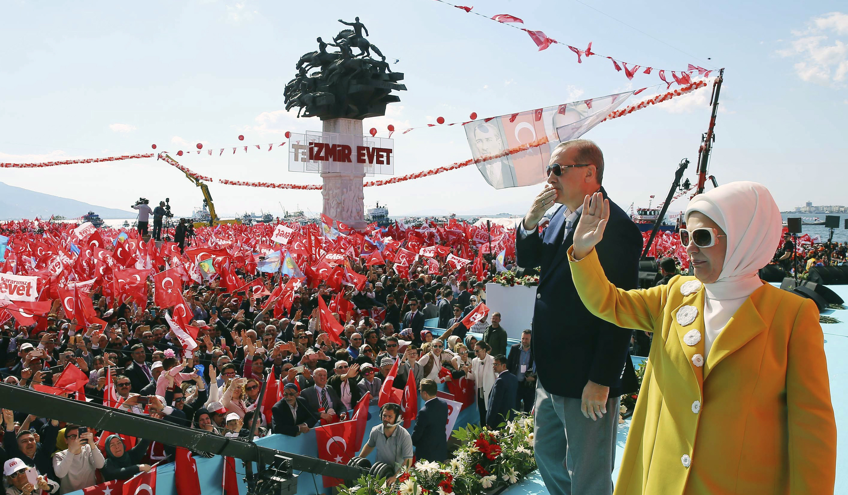 Turkey's President Recep Tayyip Erdogan and his wife Emine Erdogan salute supporters during a referendum rally in Izmir, Turkey, Sunday, April 9, 2017. Turkey is heading to a contentious April 16 referendum on constitutional reforms to expand Erdogan's powers. (Kayhan Ozer/Presidential Press Service, Pool Photo via AP)