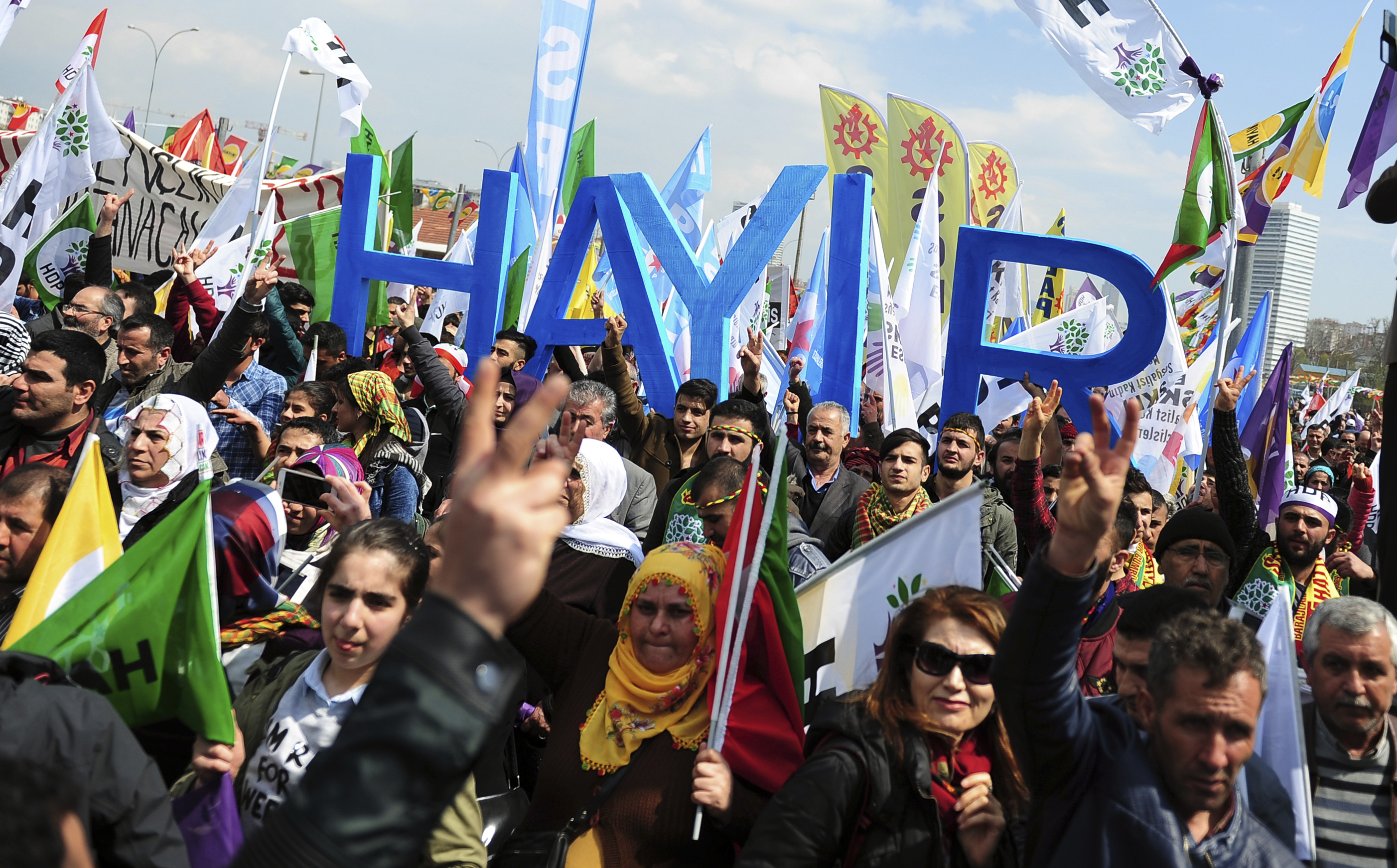 Supporters of pro-Kurdish Peoples' Democracy Party hold placards that read 