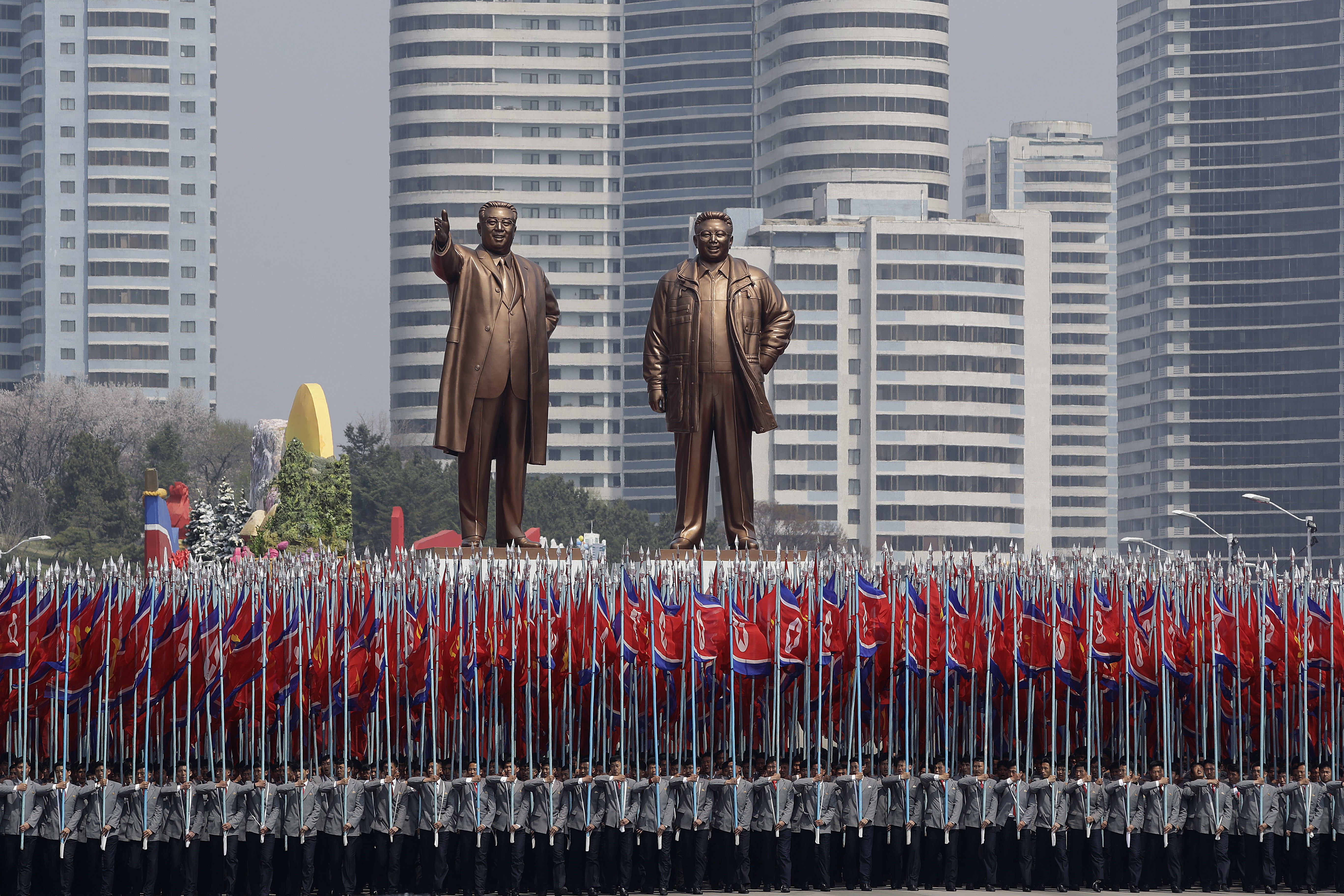In this Saturday, April 15, 2017 photo, university students carry North Korean national flags and two bronze statues of the late leaders Kim Il Sung and Kim Jong Il during a military parade in Pyongyang, North Korea, to celebrate the 105th birth anniversary of Kim Il Sung, the country's late founder and grandfather of current ruler Kim Jong Un. (AP Photo/Wong Maye-E, File)