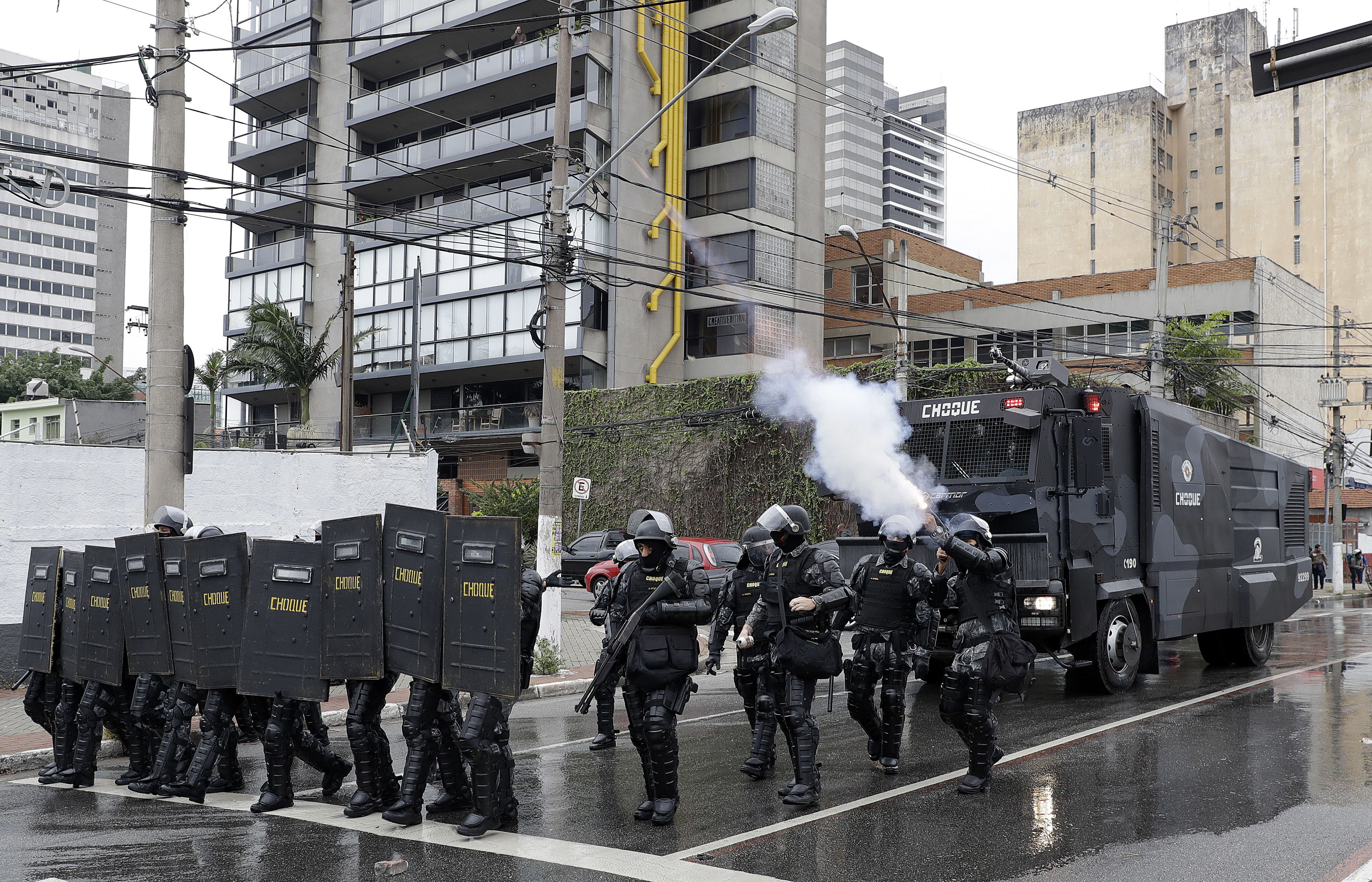Riot police fire tear gas at demonstrators, next to the Sao Paulo's University, during a general strike in Sao Paulo, Brazil, Friday, April 28, 2017. Buses, trains and metros have been halted across much of Brazil as a general strike kicks off. Transportation unions and several other groups are protesting changes to labor laws and the pension system being considered by Congress. (AP Photo/Andre Penner)