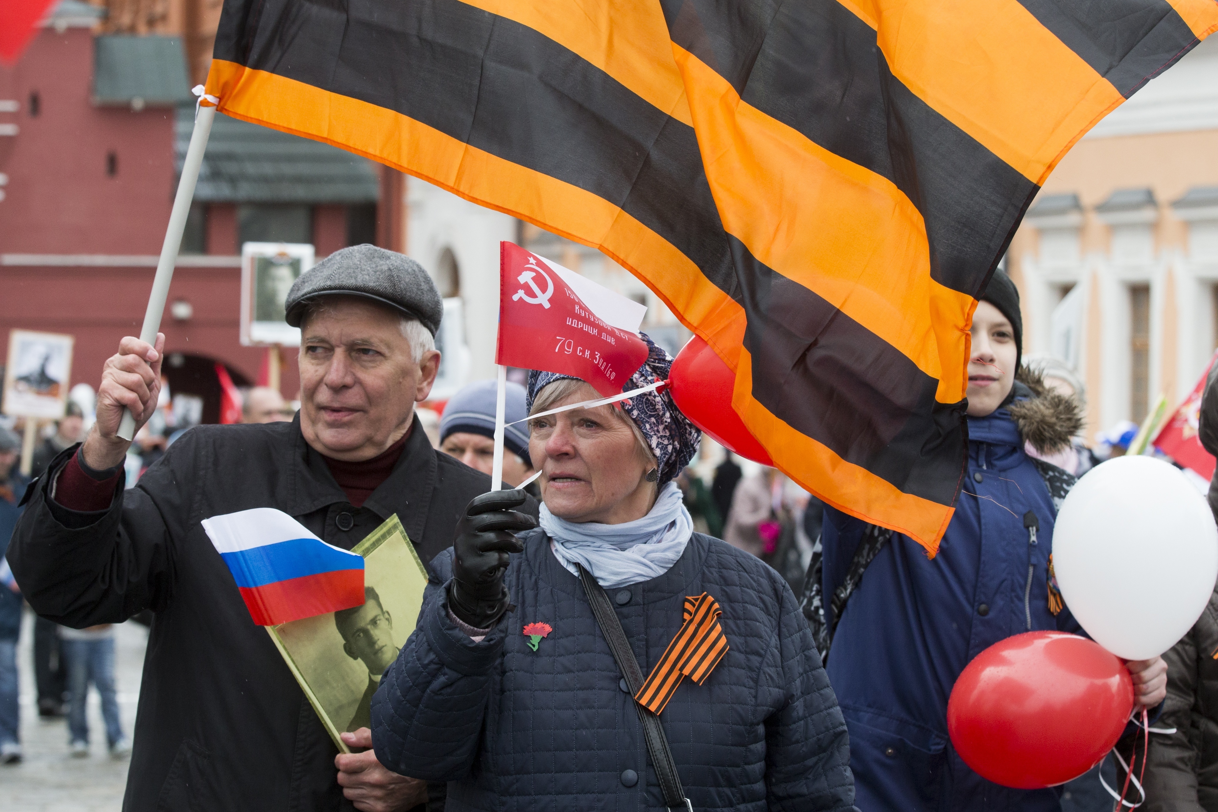 People carry portraits of relatives who fought in World War II, and Russian and Soviet flags, during the Immortal Regiment march along the Red Square in Moscow, Russia, Tuesday, May 9, 2017, celebrating 72 years since the end of WWII and the defeat of Nazi Germany. (AP Photo/Alexander Zemlianichenko)