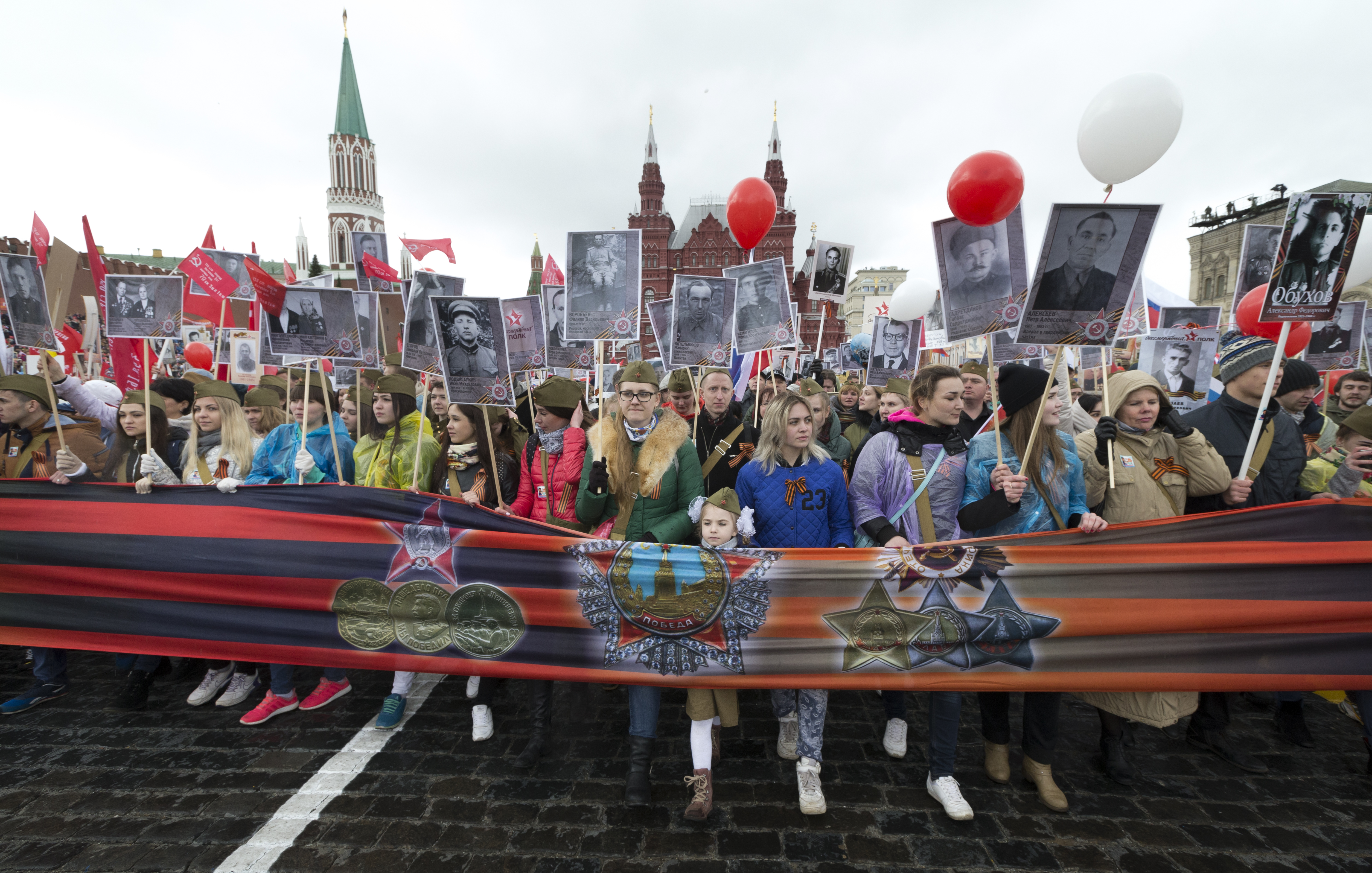 People carry portraits of relatives who fought in World War II,  with Russian and Soviet flags, during the Immortal Regiment march at the Red Square in Moscow, Russia, on Tuesday, May 9, 2017, celebrating 72 years since the end of WWII and the defeat of Nazi Germany.(AP Photo/Ivan Sekretarev)