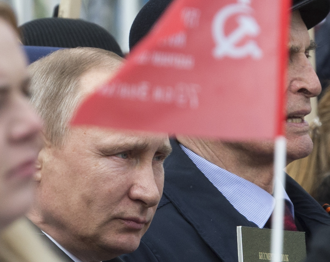 Russian President Vladimir Putin walks among other people carrying portraits of relatives who fought in World War II, with Russian and Soviet flags, during the Immortal Regiment march at the Red Square in Moscow, Russia, on Tuesday, May 9, 2017, celebrating 72 years since the end of WWII and the defeat of Nazi Germany. (AP Photo/Ivan Sekretarev)