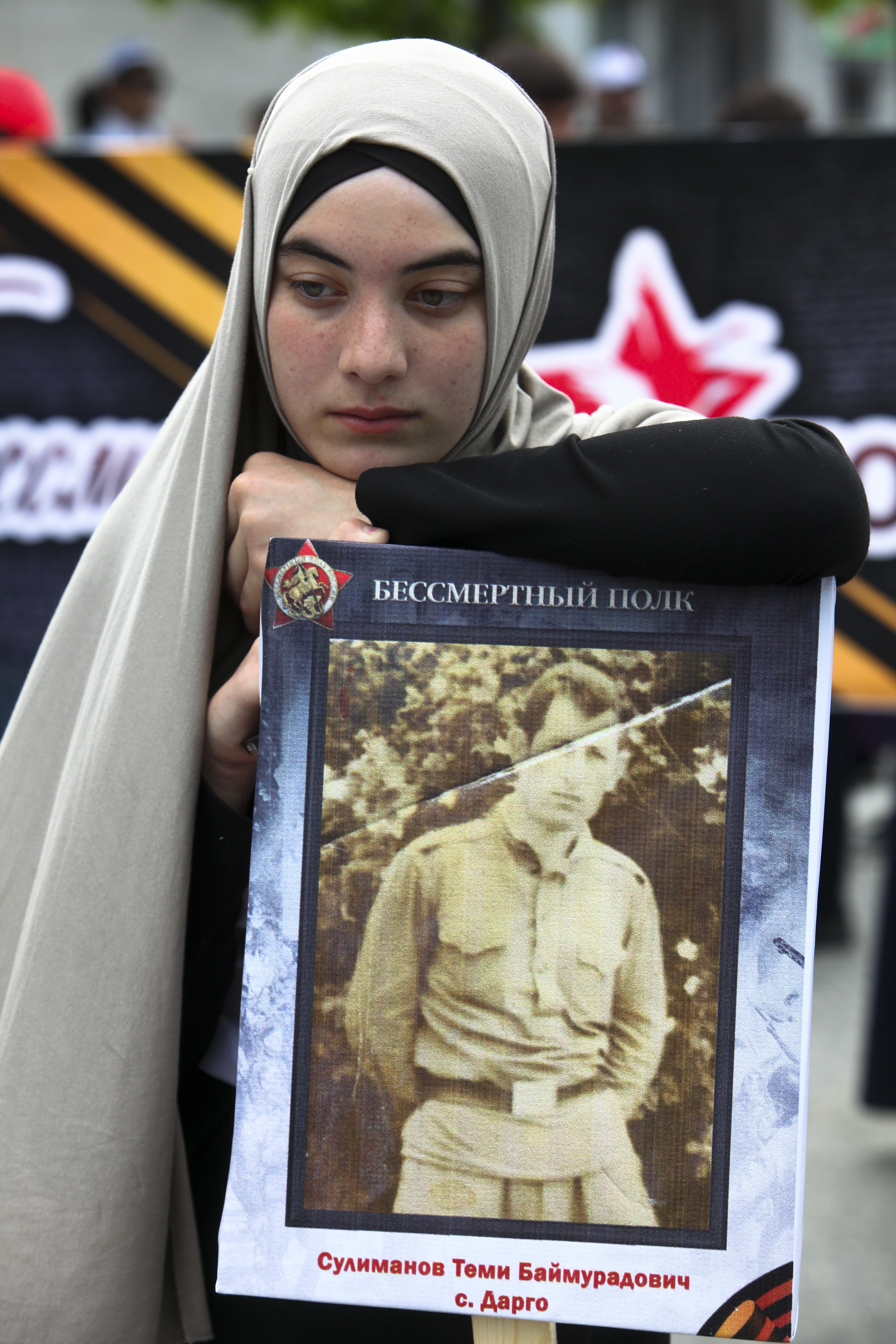 A Chechen woman holds a portrait of her relative who fought in World War II, prior to the Immortal Regiment march in the Chechnya's capital Grozny, southern Russia, Tuesday, May 9, 2017, celebrating 72 years since the end of WWII and the defeat of Nazi Germany. (AP Photo/Musa Sadulayev)