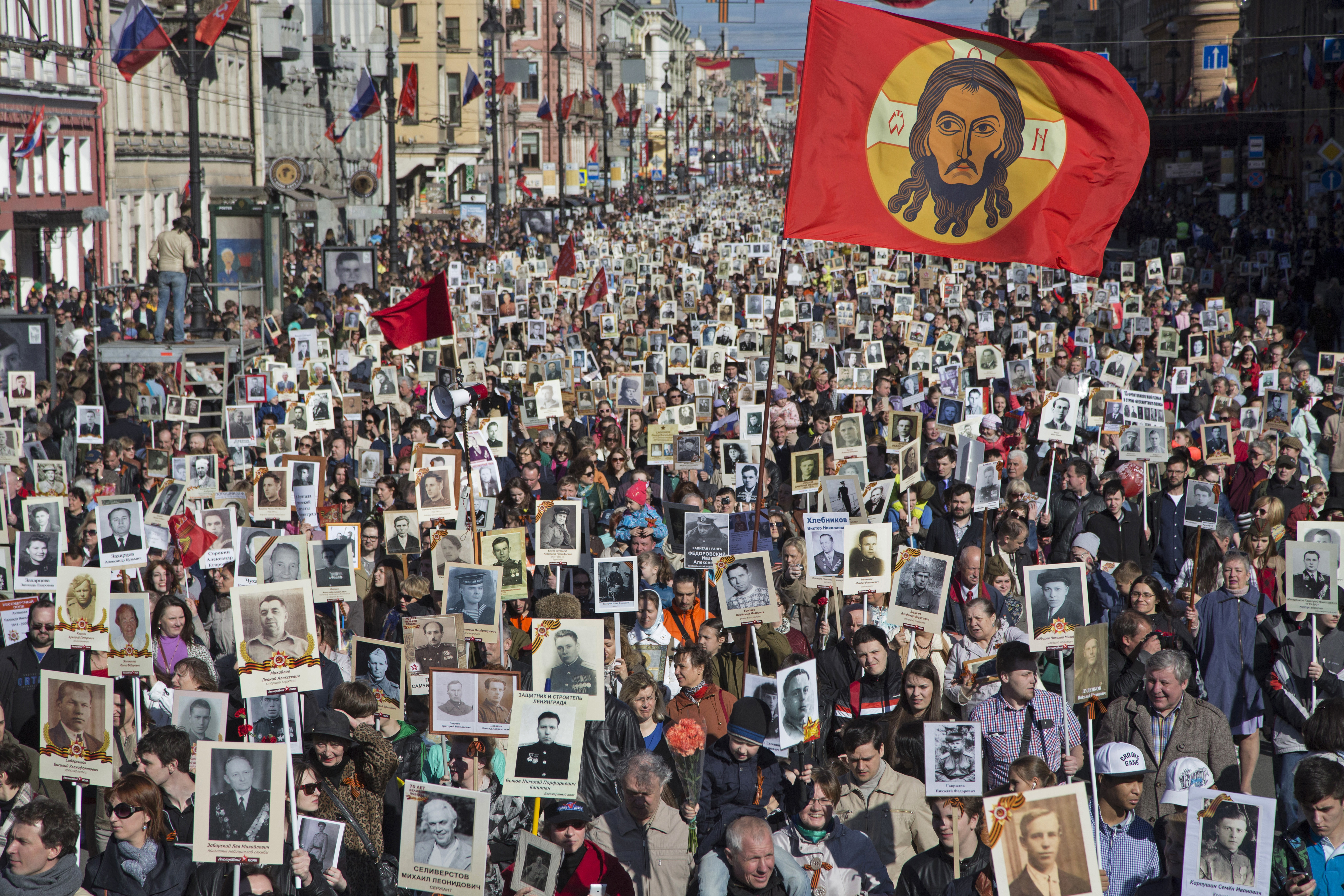 Local residents carry portraits of their ancestors, participants in World War Two as they celebrate the 70th anniversary of the defeat of the Nazis in World War II in St. Petersburg, Russia, Saturday, May 9, 2015. About 100,000 people walked in central streets in a march named 'Immortal Regiment' while carrying portraits of their relatives who fought in World War Two. (AP Photo/Dmitry Lovetsky)