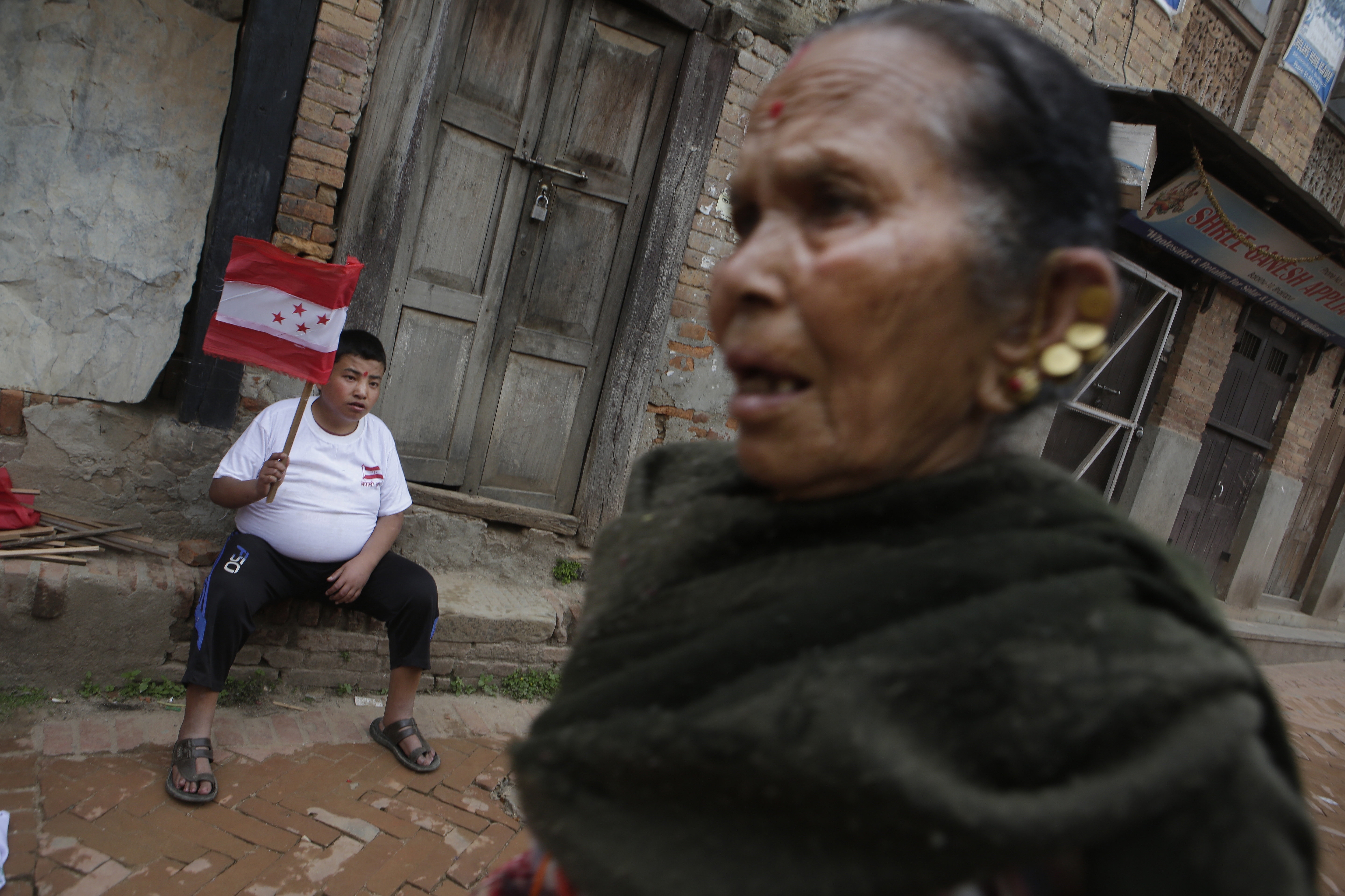 In this May 11, 2017 photo, a Nepalese teenager holds the Nepali Congress party flag in Bhaktapur, Nepal. Much has changed since Nepal last held local elections 20 years ago _ the Himalayan country's 240-year monarchy was abolished, federal democracy was introduced and political wrangling took center stage. Earthquakes ravaged the country. A Maoist insurgency left thousands dead. And widespread poverty ensured daily life for many remained a struggle if not a misery. Through it all, Nepal's 29 million citizens have had only government-appointed bureaucrats to look to for answers or help with settling local disputes. Many voters said they were excited for the chance this weekend to choose local representatives for the first time since 1997.(AP Photo/Niranjan Shrestha)