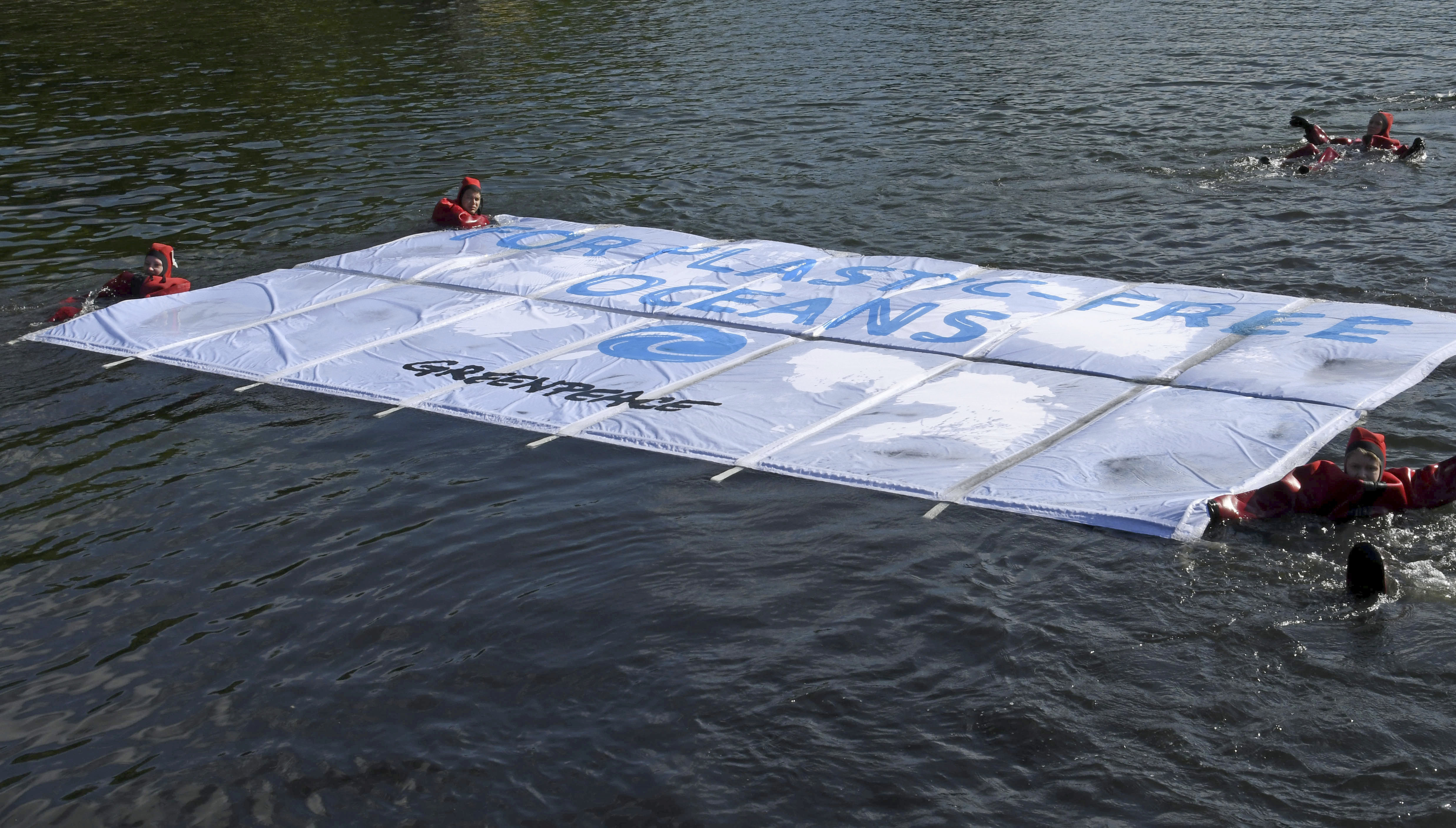 Greenpeace activists unfold a floating banner in Hollersee lake as part of the campaign 