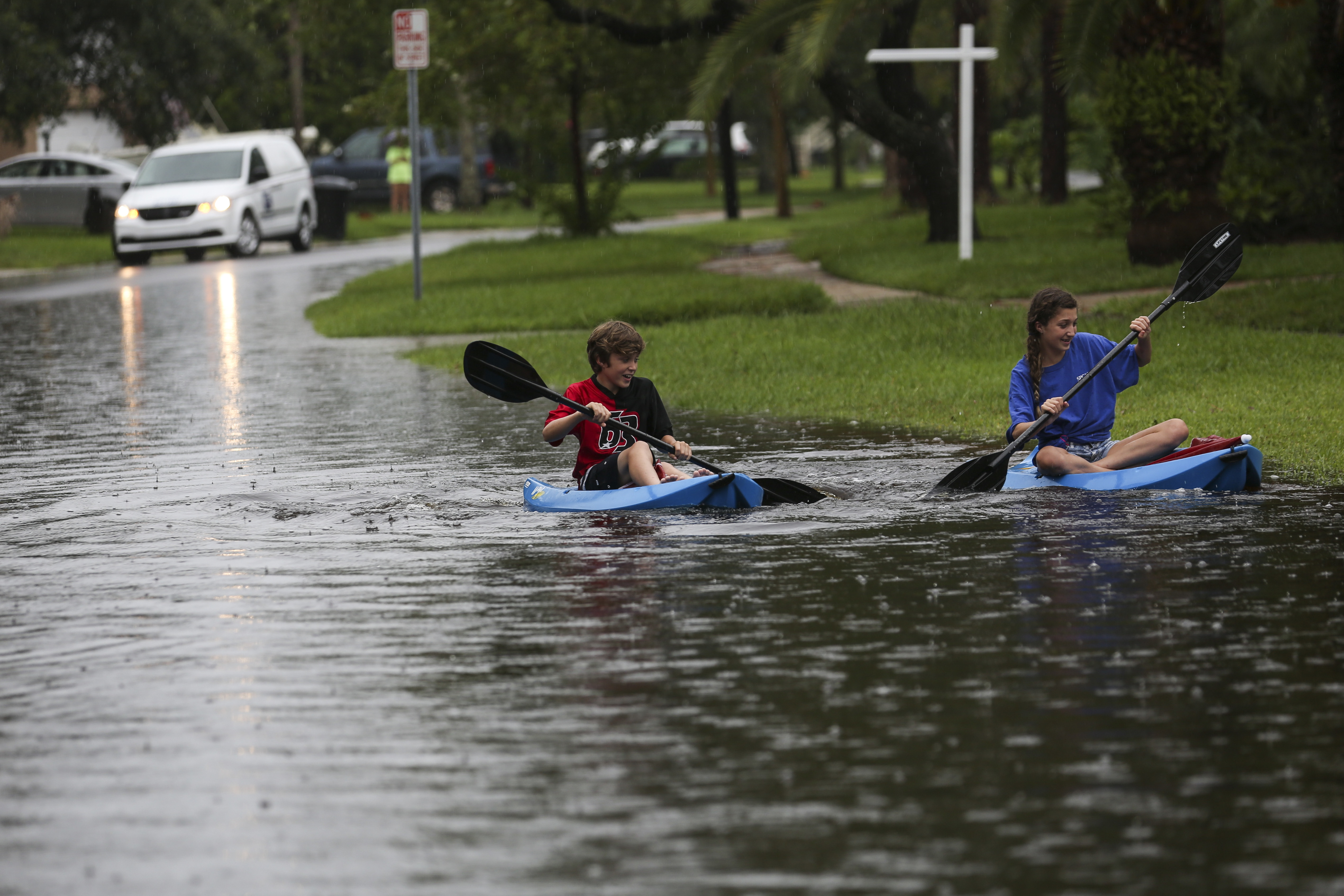 Brian Vaughan, 10 and his sister Brianna Vaughan, 13, paddle in their kayaks down their street, Venetian Blvd NE in Shore Acres on Wednesday, June 7, 2017, in St. Petersburg, Fla. Heavy rains that have hit South Florida the past couple of days. (Eve Edelheit/Tampa Bay Times via AP)