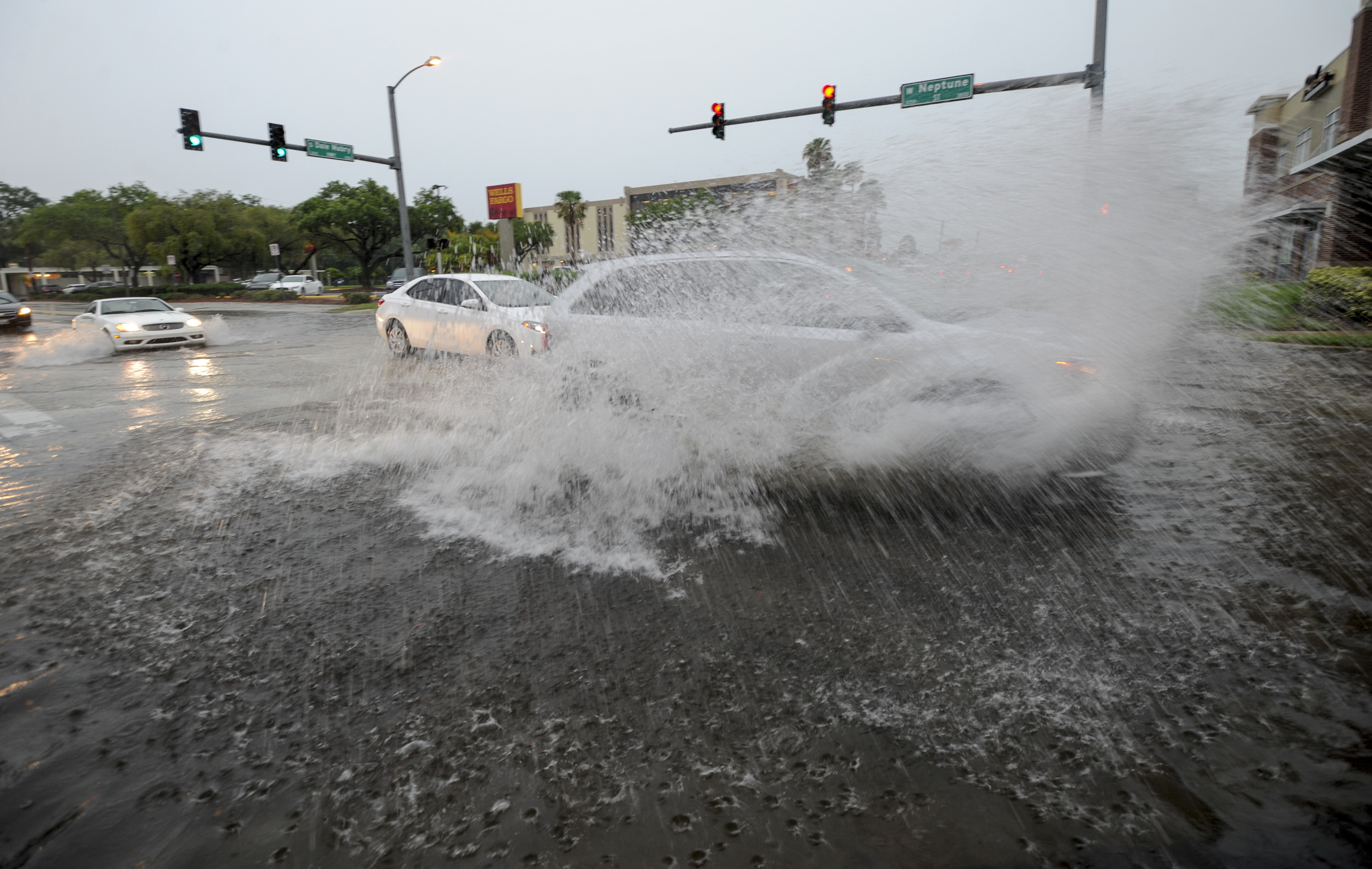 A driver speeds through the flooded intersection of Dale Mabry Highway and Neptune Street Wednesday, June 7, 2017, in Tampa. Heavy rains that have hit South Florida the past couple of days. (Chris Urso/Tampa Bay Times via AP)