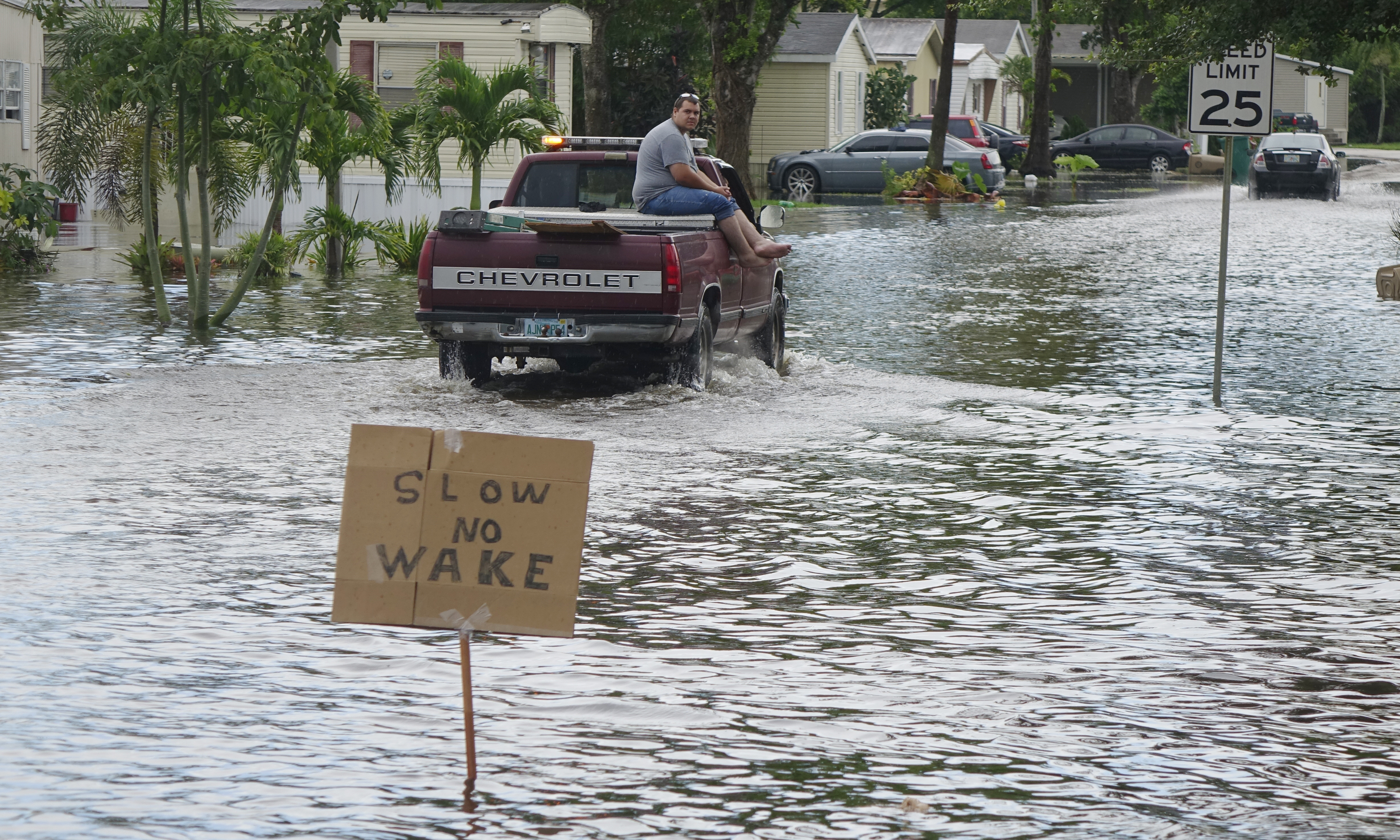 A sign on the swale on SW 135 terrace asks motorist to go slow in Sunshine Village in Davie, Fla.,Wednesday, June 7, 2017. Several days of constant rain has caused flooding throughout Broward and Palm Beach Counties.  (Joe Cavaretta/South Florida Sun-Sentinel via AP)