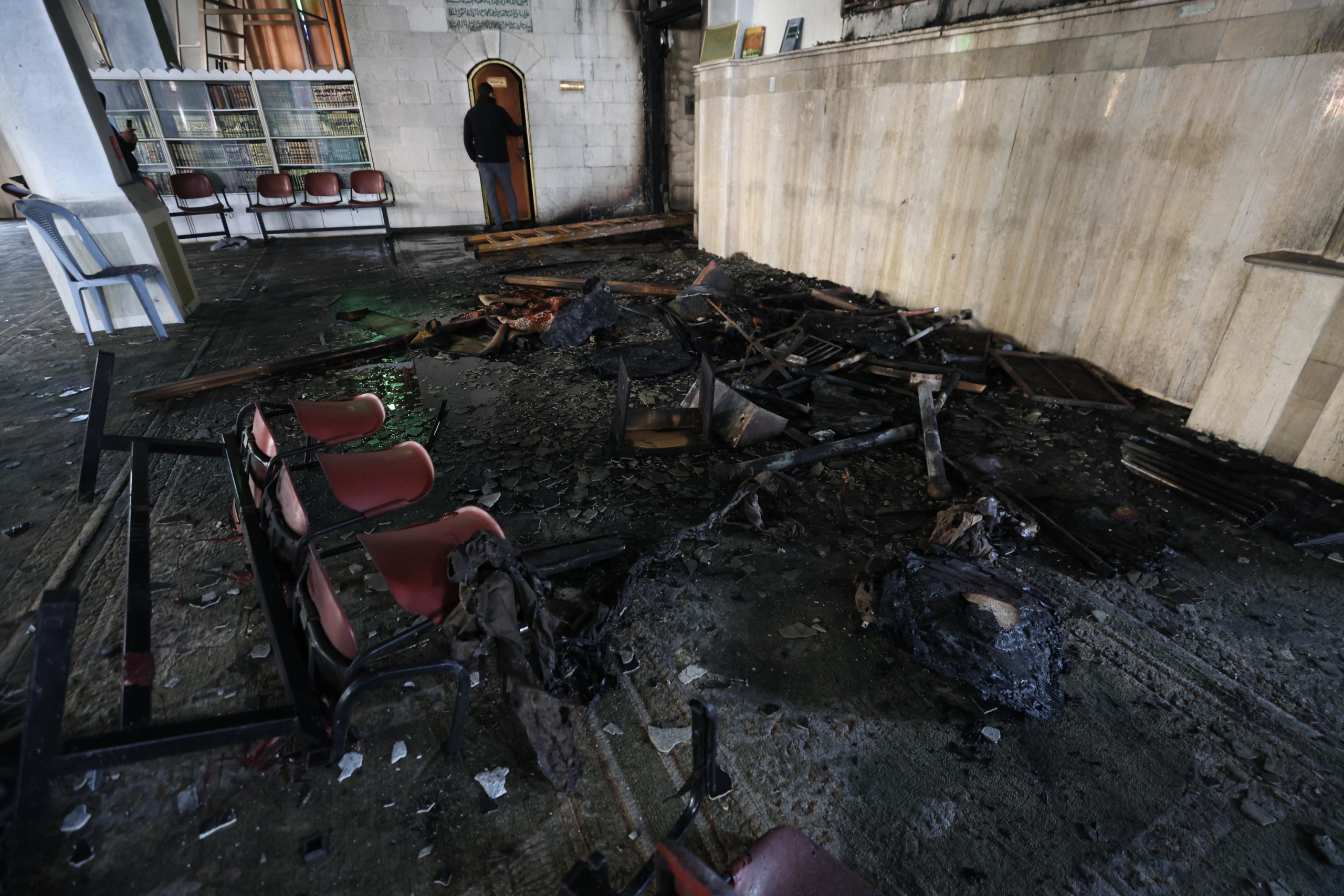 epa11946436 Palestinians inspect the damage inside Al-Nasr Mosque, following an Israeli military raid in the old city of Nablus, West Bank, 07 March 2025. According to the Palestinian news agency Wafa, Israeli military forces raided several mosques in the old city of Nablus at dawn on 07 March, and set the Al-Nasr Mosque on fire.  EPA/ALAA BADARNEH