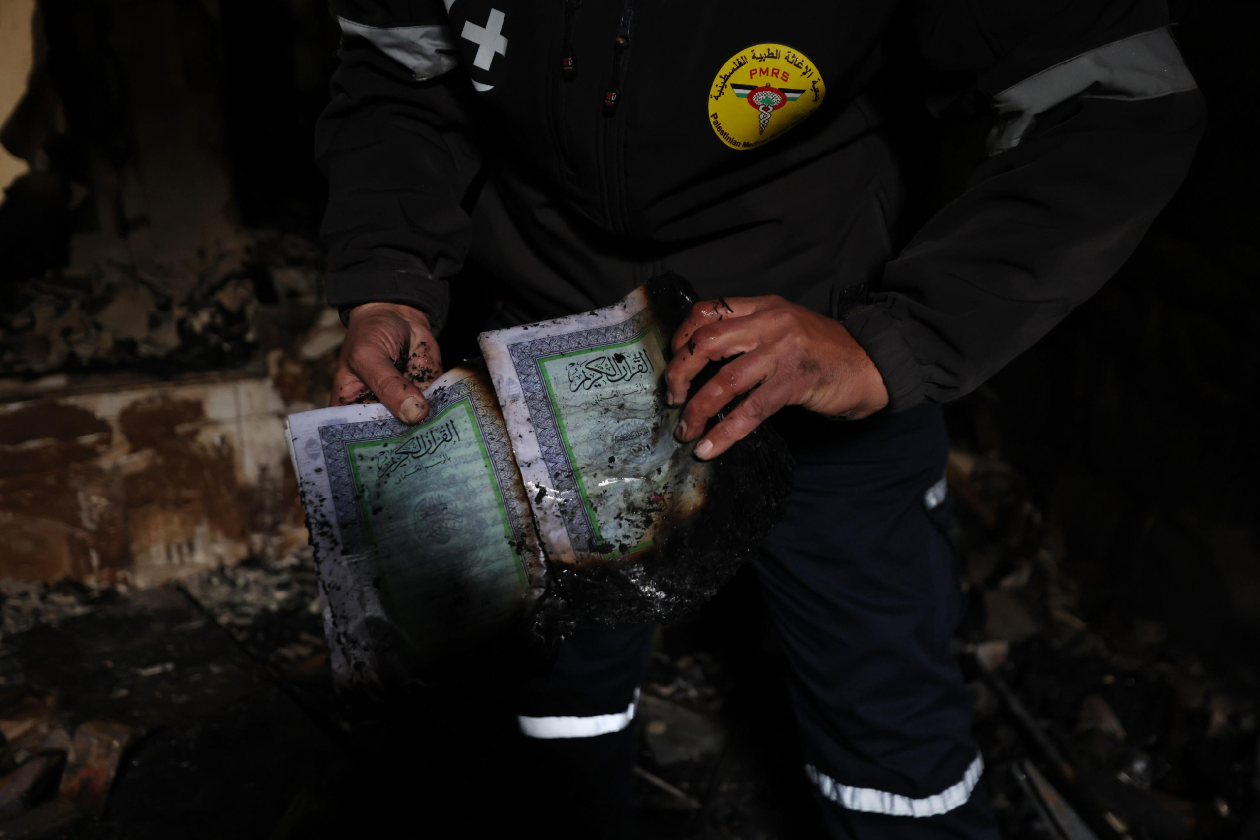 epa11946458 A Palestinian man displays a burned Koran  inside Al-Nasr Mosque, following an Israeli military raid in the old city of Nablus, West Bank, 07 March 2025. According to the Palestinian news agency Wafa, Israeli military forces raided several mosques in the old city of Nablus at dawn on 07 March, and set the Al-Nasr Mosque on fire.  EPA/ALAA BADARNEH