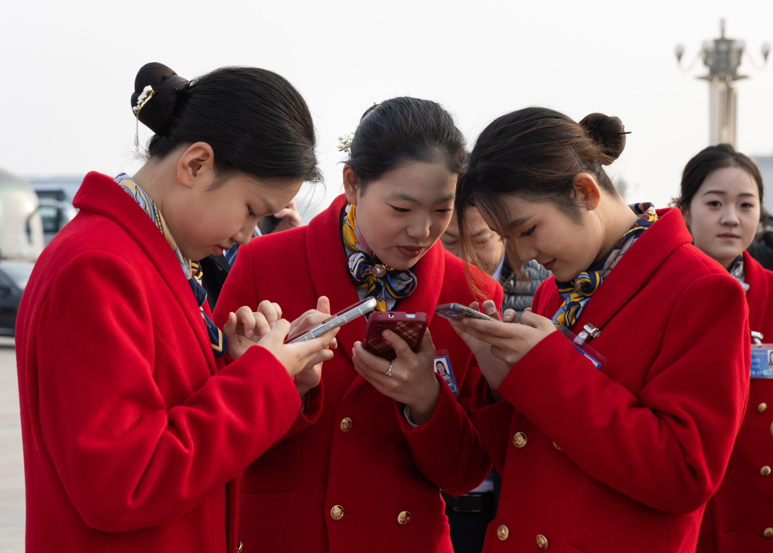 epa11952995 Staff members look at their phones during the Closing Session of the Chinese People's Political Consultative Conference (CPPCC) at the Great Hall of the People in Beijing, China, 10 March 2025. China holds two major annual political meetings: the National People's Congress (NPC) and the Chinese People's Political Consultative Conference (CPPCC), which run alongside each other and are collectively known as the 'Lianghui' or 'Two Sessions.  EPA/JESSICA LEE