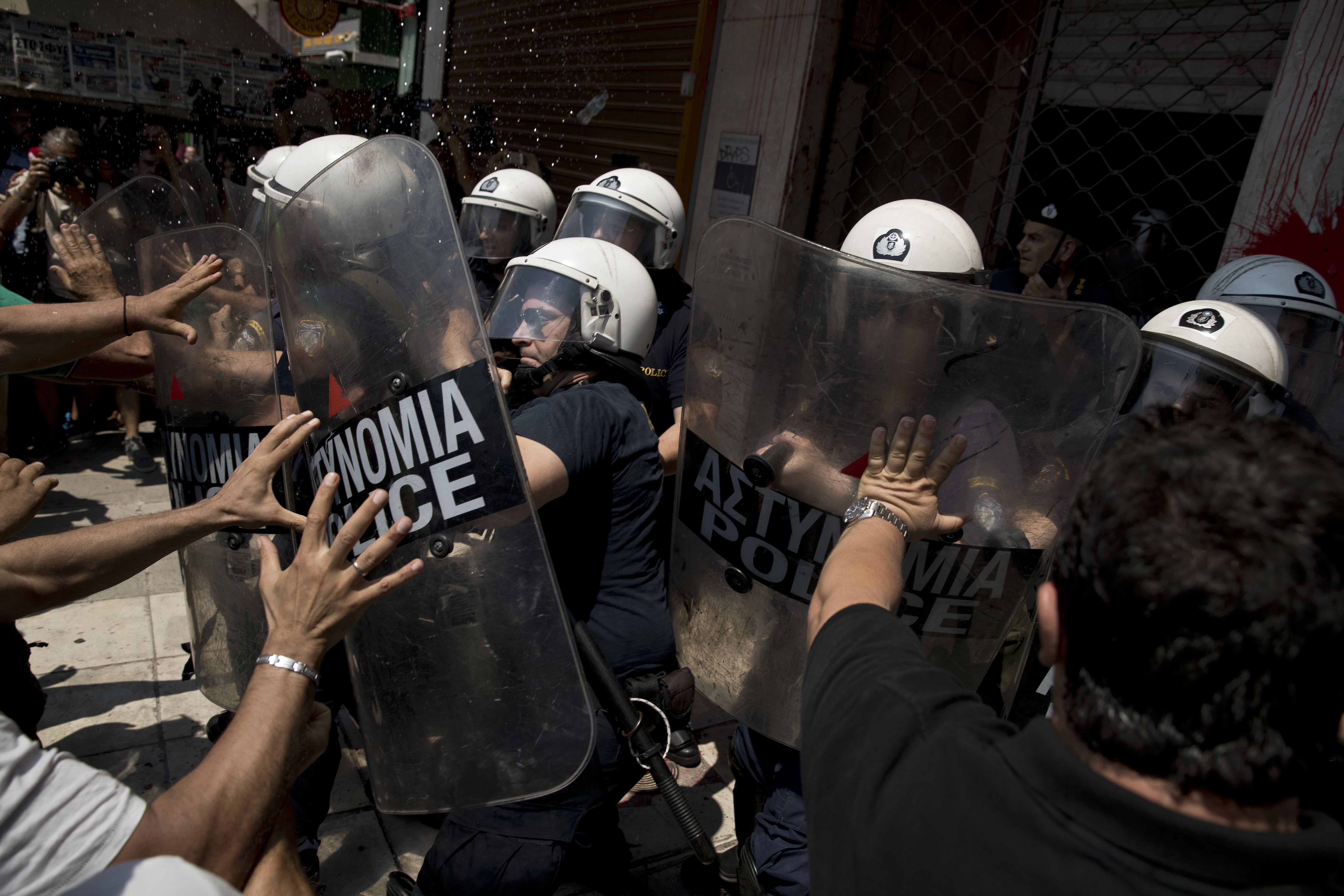 Striking municipal workers scuffle with riot police who are guarding the entrance of the Interior Ministry during a protest, in Athens, on Monday June 26, 2017. With a heat wave expected later this week, Greece's government Monday urging striking garbage collectors to return to work after a 10-day protest has left huge piles of trash around Athens. (AP Photo/Petros Giannakouris)