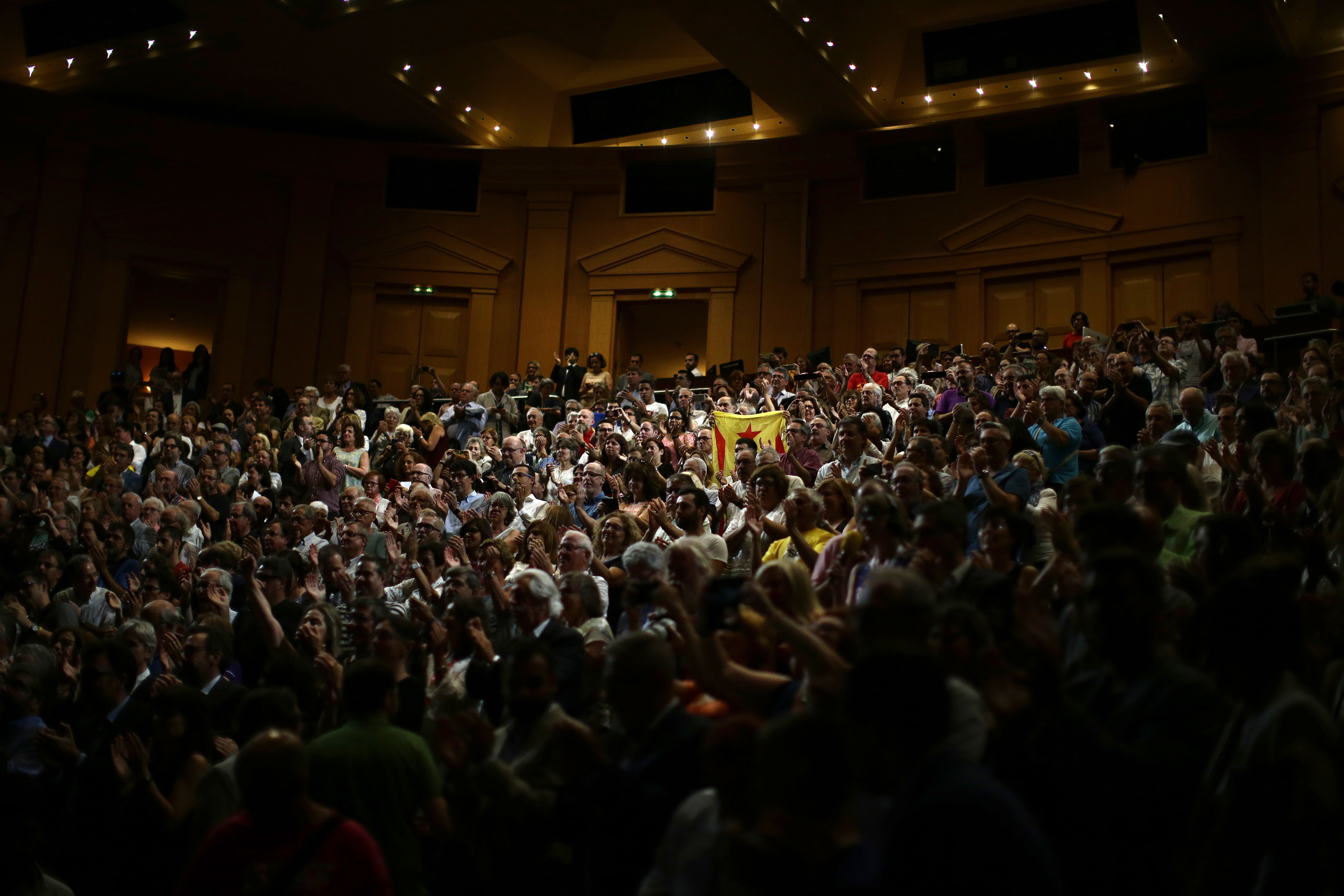 People applaud during a pro-independence meeting in Barcelona, Spain, Tuesday, July, 4, 2017. Catalonia's regional government chose October 1st for a referendum on a split from Spain, stepping up the confrontation with central authorities who see the vote as illegal. (AP Photo/Manu Fernandez)