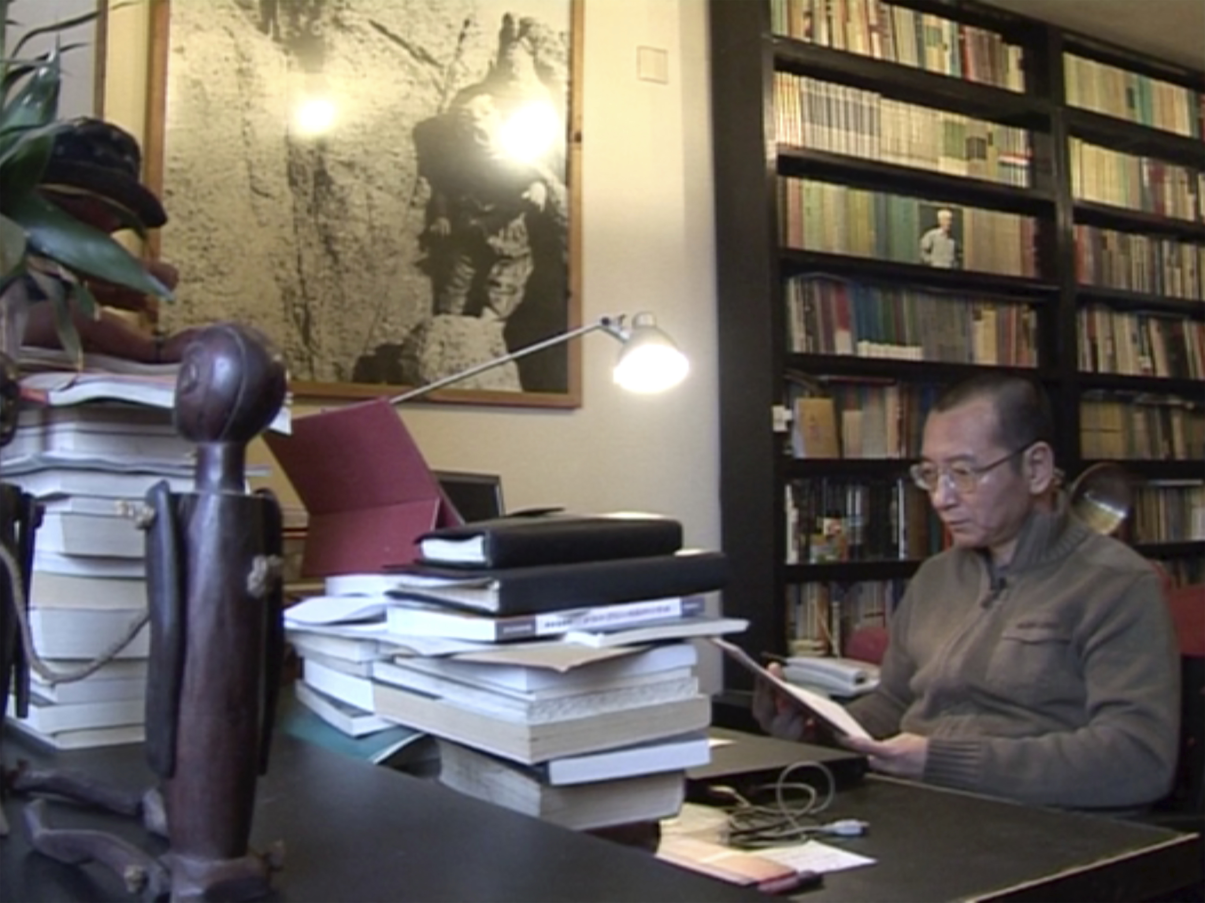 In this image taken from Jan. 6, 2008, video footage by AP Video, Liu Xiaobo looks at documents in his home in Beijing, China. At various times until his final incarceration in 2008, Liu Xiaobo's career as a lecturer, writer and literary critic intersected with China's pro-democracy movement that has been harried at every turn by the repressive powers of the one-party Communist state. (AP Video via AP)