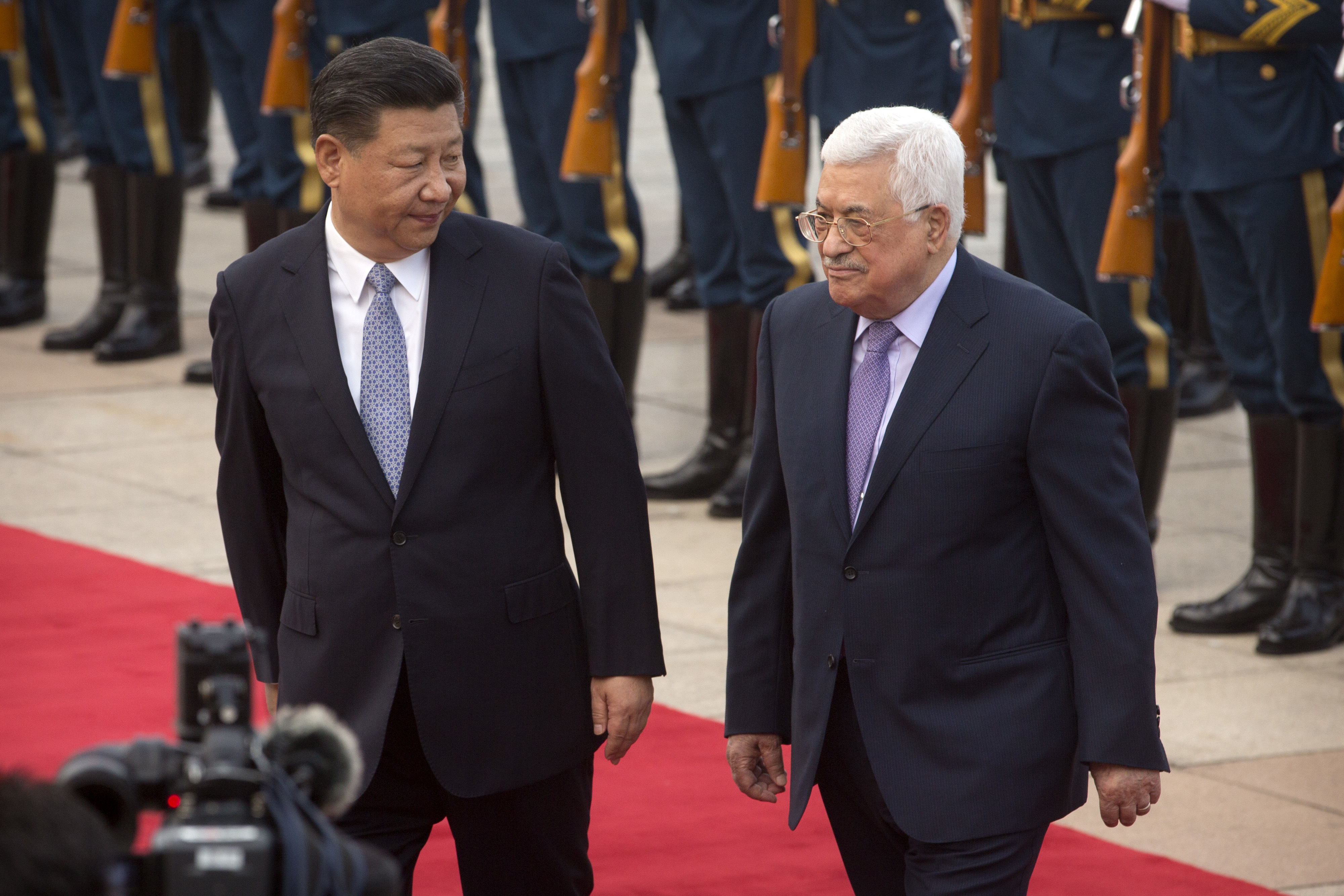 Chinese President Xi Jinping, left, looks at Palestinian President Mahmoud Abbas, right, as they walk together during a welcome ceremony at the Great Hall of the People in Beijing, Tuesday, July 18, 2017. (AP Photo/Mark Schiefelbein)