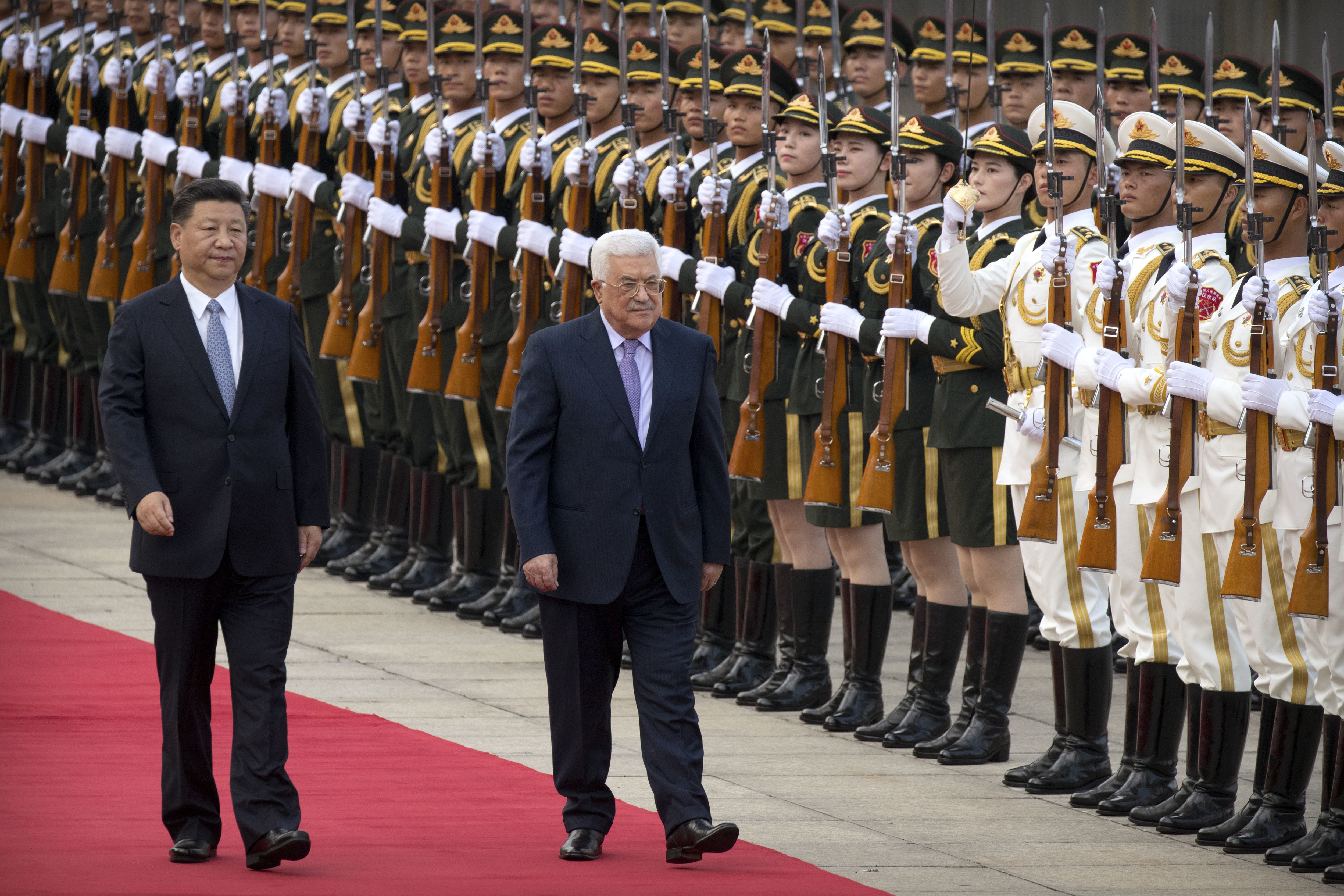 Chinese President Xi Jinping, left, and Palestinian President Mahmoud Abbas reviews an honor guard during a welcome ceremony at the Great Hall of the People in Beijing, Tuesday, July 18, 2017. (AP Photo/Mark Schiefelbein)