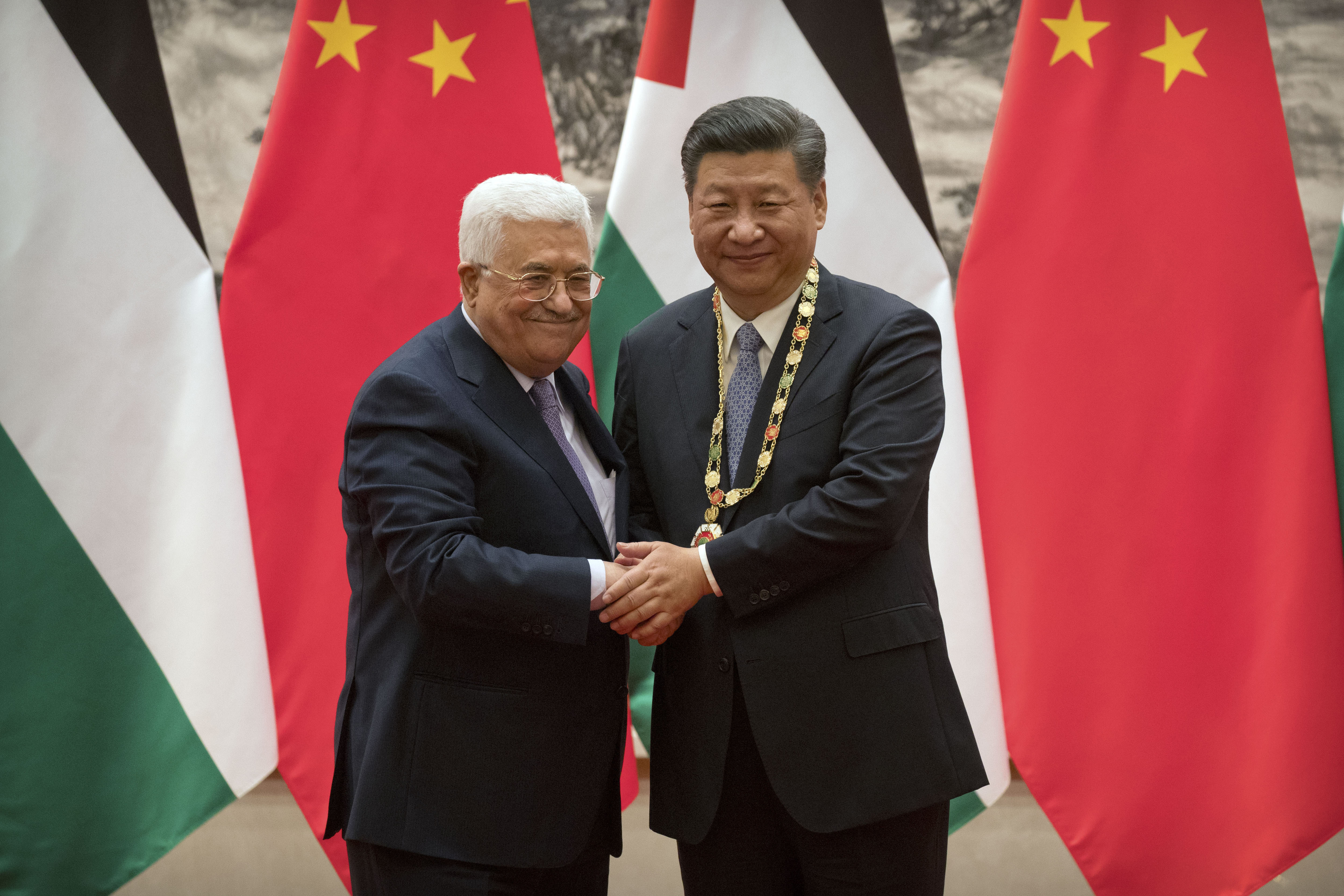 Palestinian President Mahmoud Abbas, left, pose for a photo after presenting a medallion to Chinese President Xi Jinping, right, during a signing ceremony at the Great Hall of the People in Beijing, Tuesday, July 18, 2017. (AP Photo/Mark Schiefelbein, Pool)