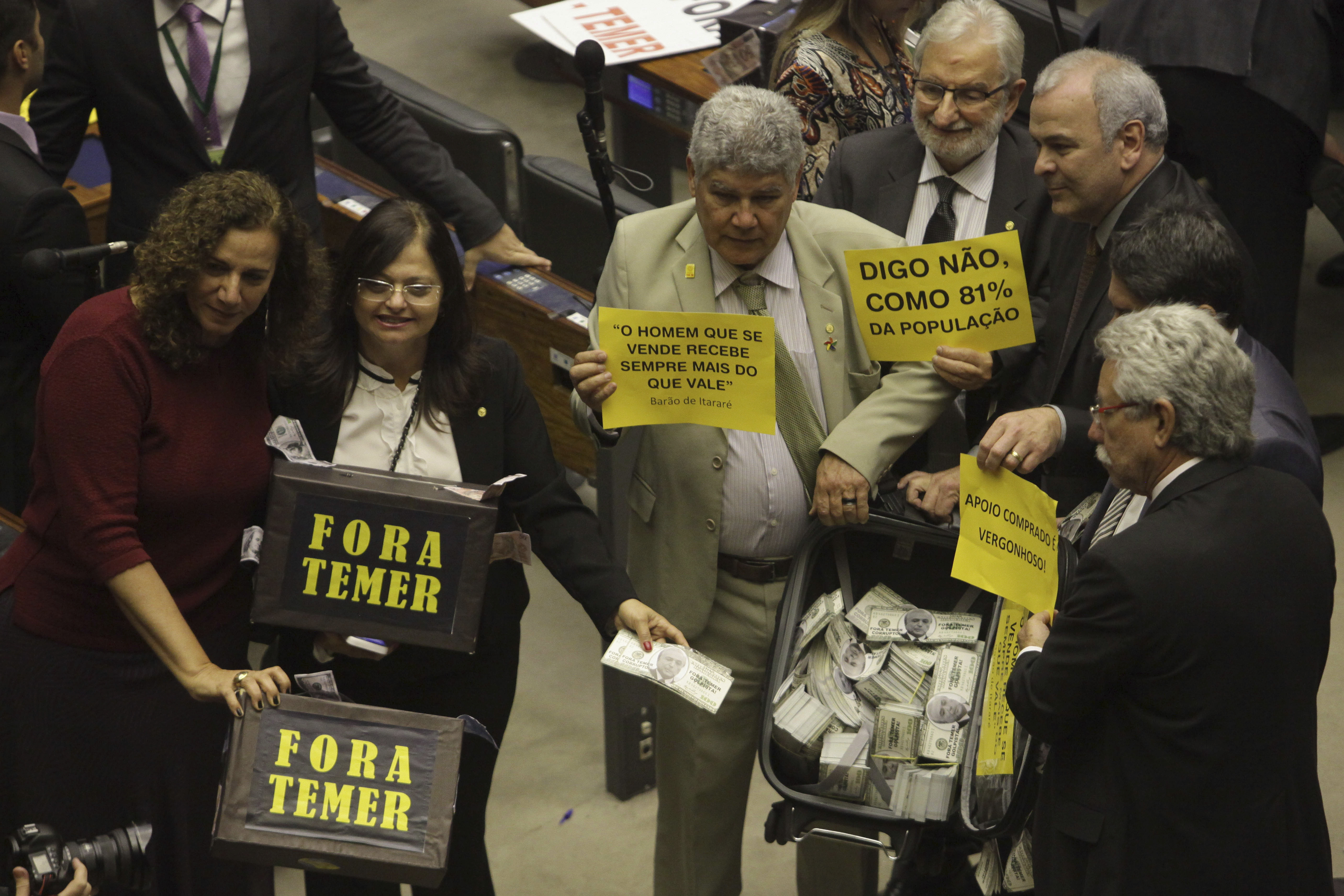 Deputies from opposition parties carry signs that read in Portuguese 