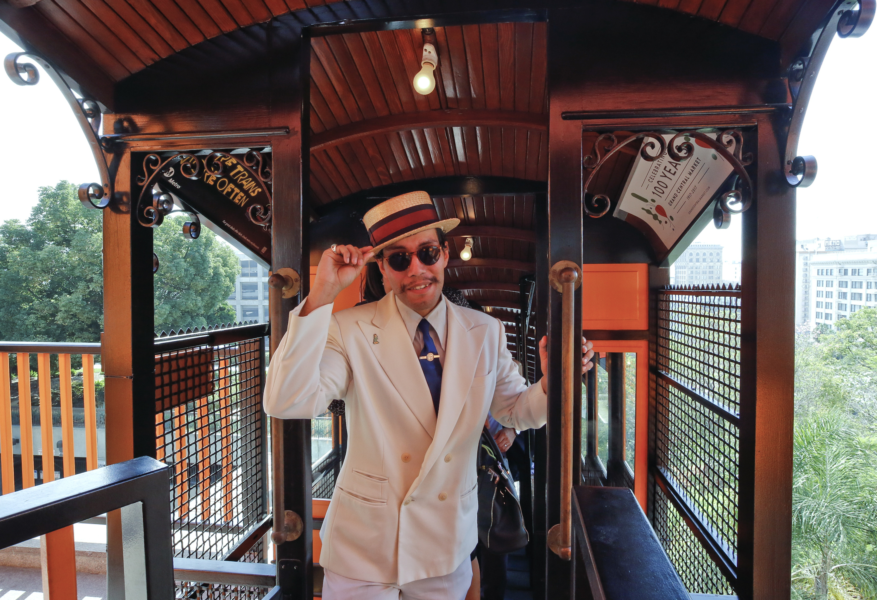 Donovan Sinohue dressed in 1920's period clothing, wears a straw boater hat, as he rides the Angels Flight downtown Los Angeles Thursday, Aug. 31, 2017. Angels Flight, the beloved little railroad that's almost as much a symbol of Los Angeles as the Hollywood Sign, began pulling people toward the heavens and back down again Thursday after four years of idleness triggered by a 2013 derailment. (AP Photo/Damian Dovarganes)