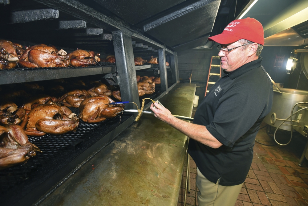 Chris Bosley checks the temperatures of barbecued turkeys as they cook on the pit on Monday at Moonlite Bar-B-Q Inn in Owensboro, Ky., on November 20, 2017. The restaurant will cook about 500 turkeys and 100 hams that customers have either bought from the restaurant or have brought in for them to cook on the pit over Thanksgiving week. Thanksgiving week is just the warm up for the Christmas holidays where they will cook about 2000 hams and 20 turkeys to fill customers orders.  (Alan Warren/The Messenger-Inquirer via AP)