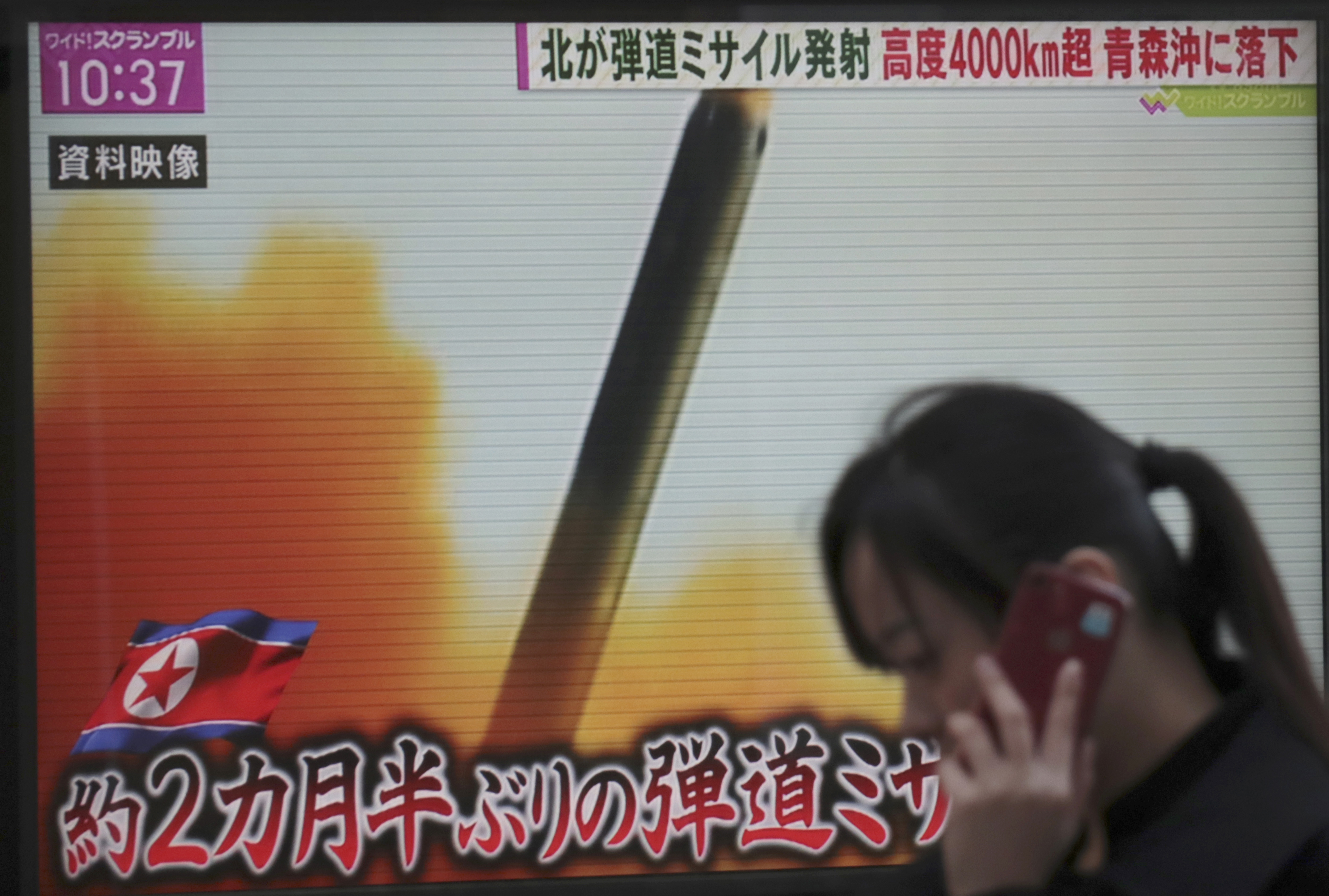 A woman walks past a TV screen broadcasting news of North Korea's missile launch, in Tokyo, Wednesday, Nov. 29, 2017. After 2 ½ months of relative peace, North Korea launched its most powerful weapon yet early Wednesday, a presumed intercontinental ballistic missile that could put Washington and the entire eastern U.S. seaboard within range. The letters at bottom read 