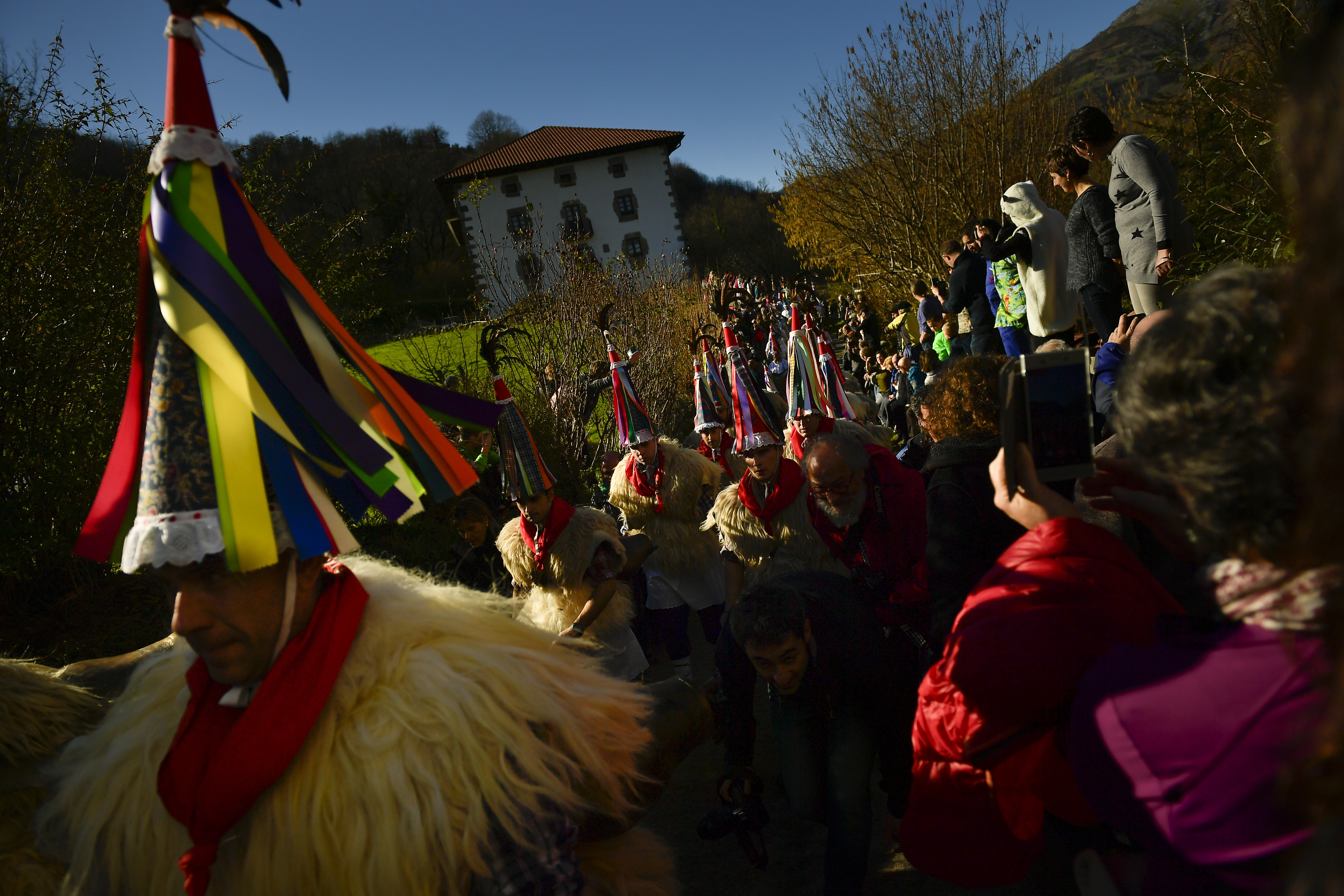 A group of Joaldunaks called Zanpantzar, take part in the Carnival between the Pyrenees villages of Ituren and Zubieta, northern Spain, Monday, Jan. 29, 2018. In one of the most ancient carnivals in Europe, dating from before the Roman empire, companies of Joaldunak (cowbells) made up of residents of two towns, Ituren and Zubieta, parade the streets costumed in sandals, lace petticoats, sheepskins around the waist and shoulders, coloured neckerchiefs, conical caps with ribbons and a hyssop of horsehair in their right hands and cowbells hung across their lower back. (AP Photo/Alvaro Barrientos)