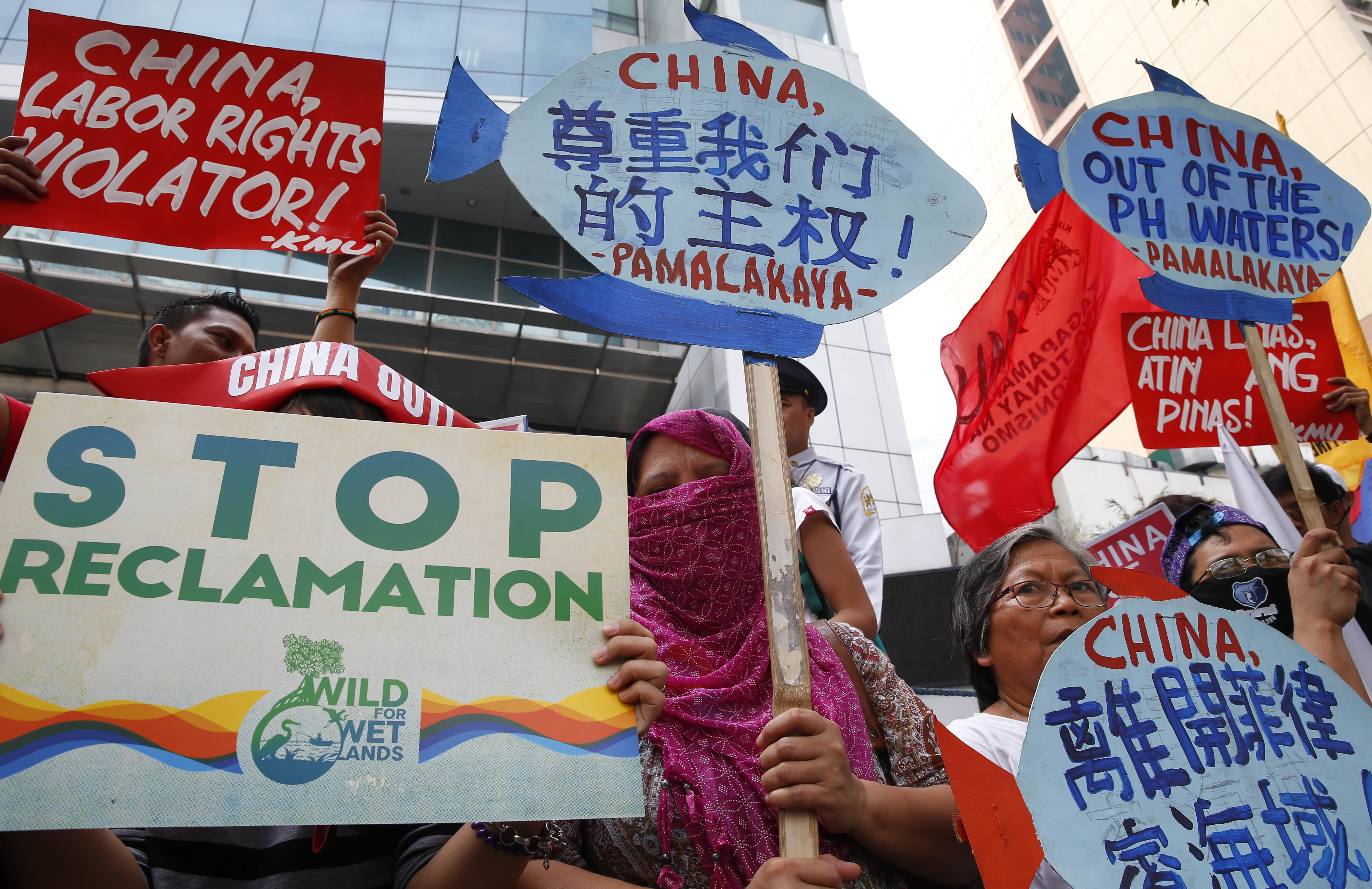 Protesters display placards during a rally at the Chinese Consulate to protest China's alleged continued militarization of the disputed islands in the South China Sea known as Spratlys Saturday, Feb. 10, 2018 in the financial district of Makati city east of Manila, Philippines. The protesters also denounced President Rodrigo Duterte's inaction over China's continued build up of military facilities and structures at the disputed islands. (AP Photo/Bullit Marquez)