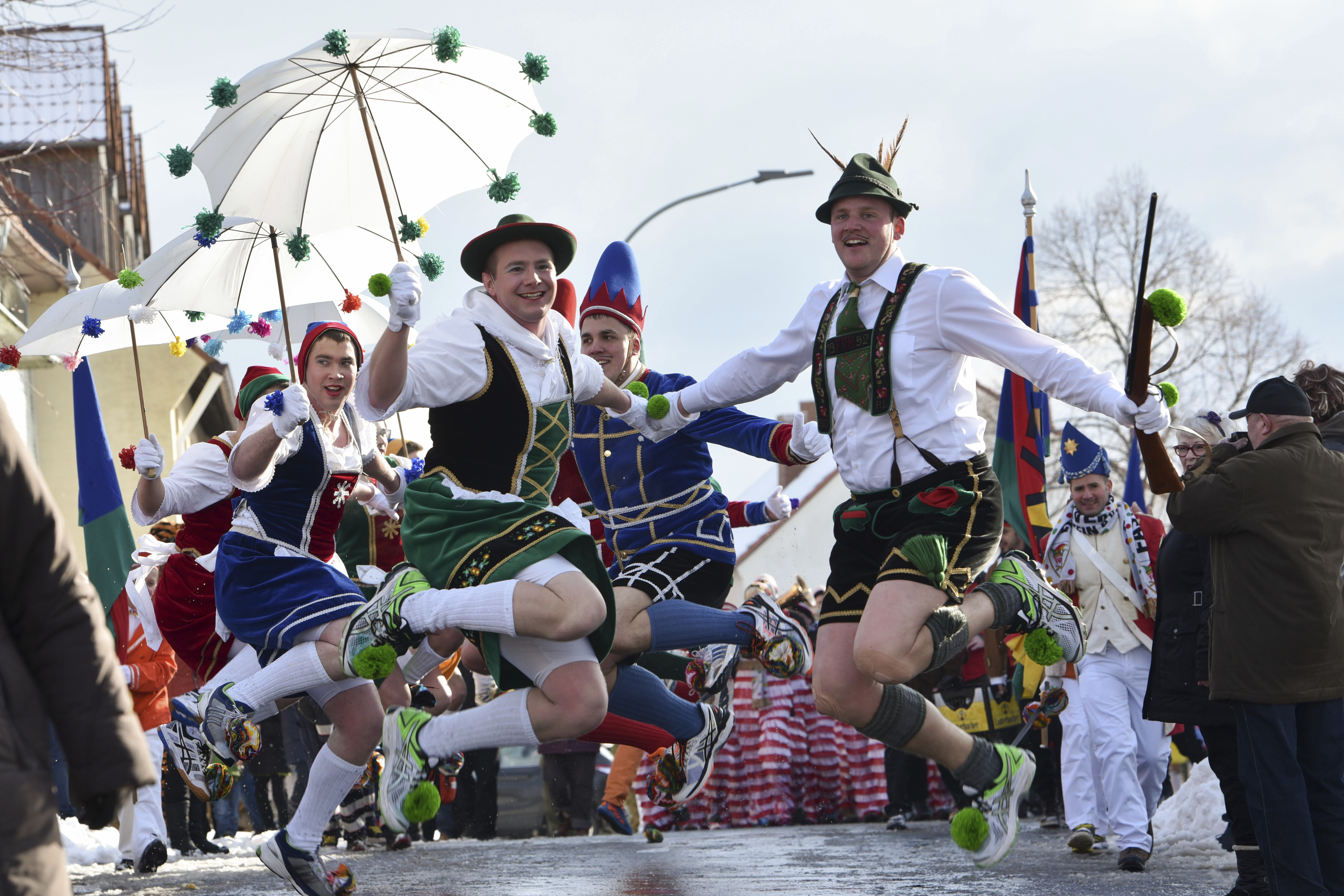 'Tiroler Paerchen' (lit. Tirol couples) jump up in the air during the parade in Herbstein, Germany, 12 February 2018. The 'Herbsteiner Springerzug' (lit. Herbstein jumping parade) is one of the most extraordinary carnival processions in Hesse. Photo by: Uwe Zucchi/picture-alliance/dpa/AP Images