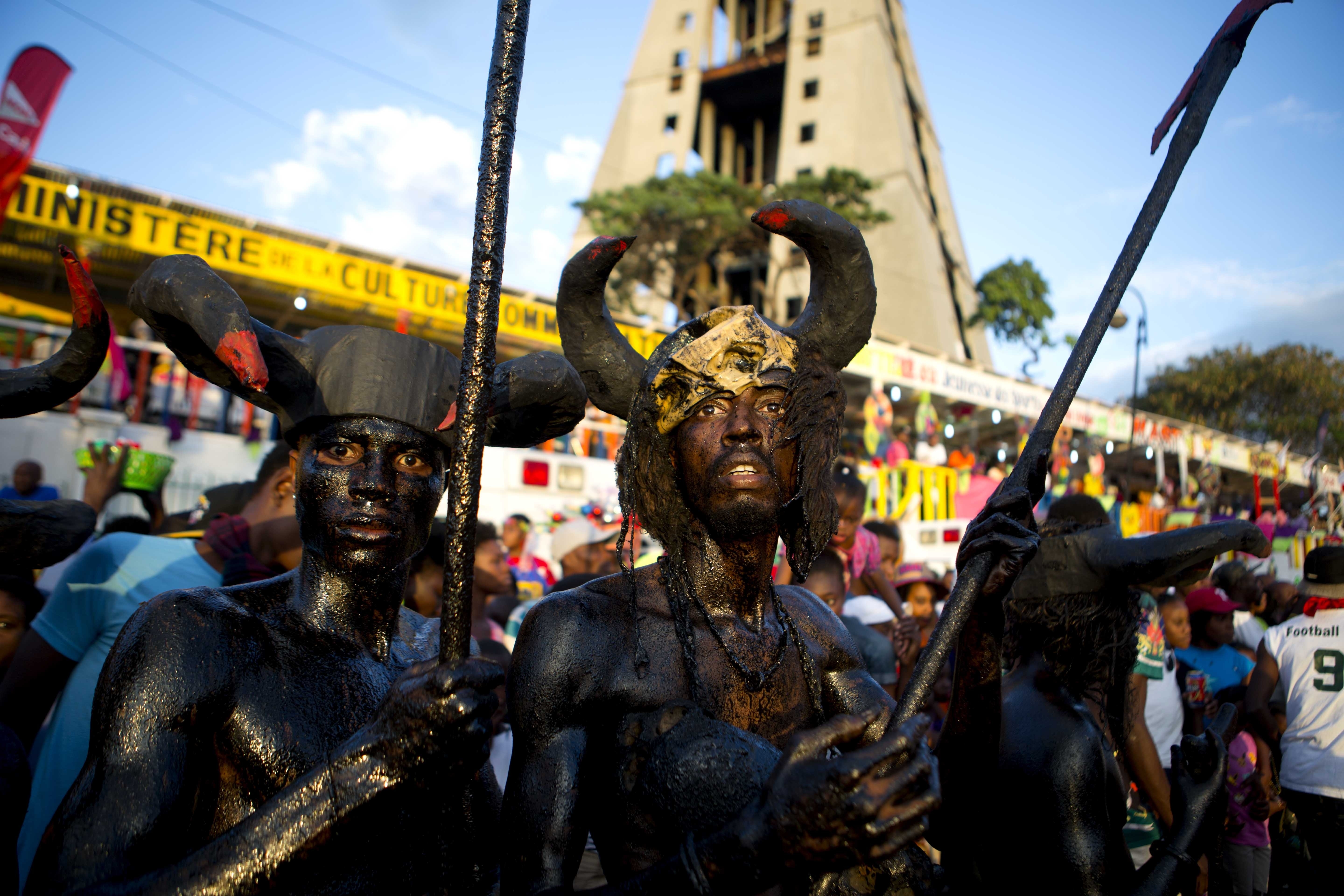 Revelers dressed as devils and with their bodies smothered with clay mud and oil, parade through the streets during Carnival in Port-au-Prince, Haiti, Monday, Feb. 12, 2018. (AP Photo/Dieu Nalio Chery)