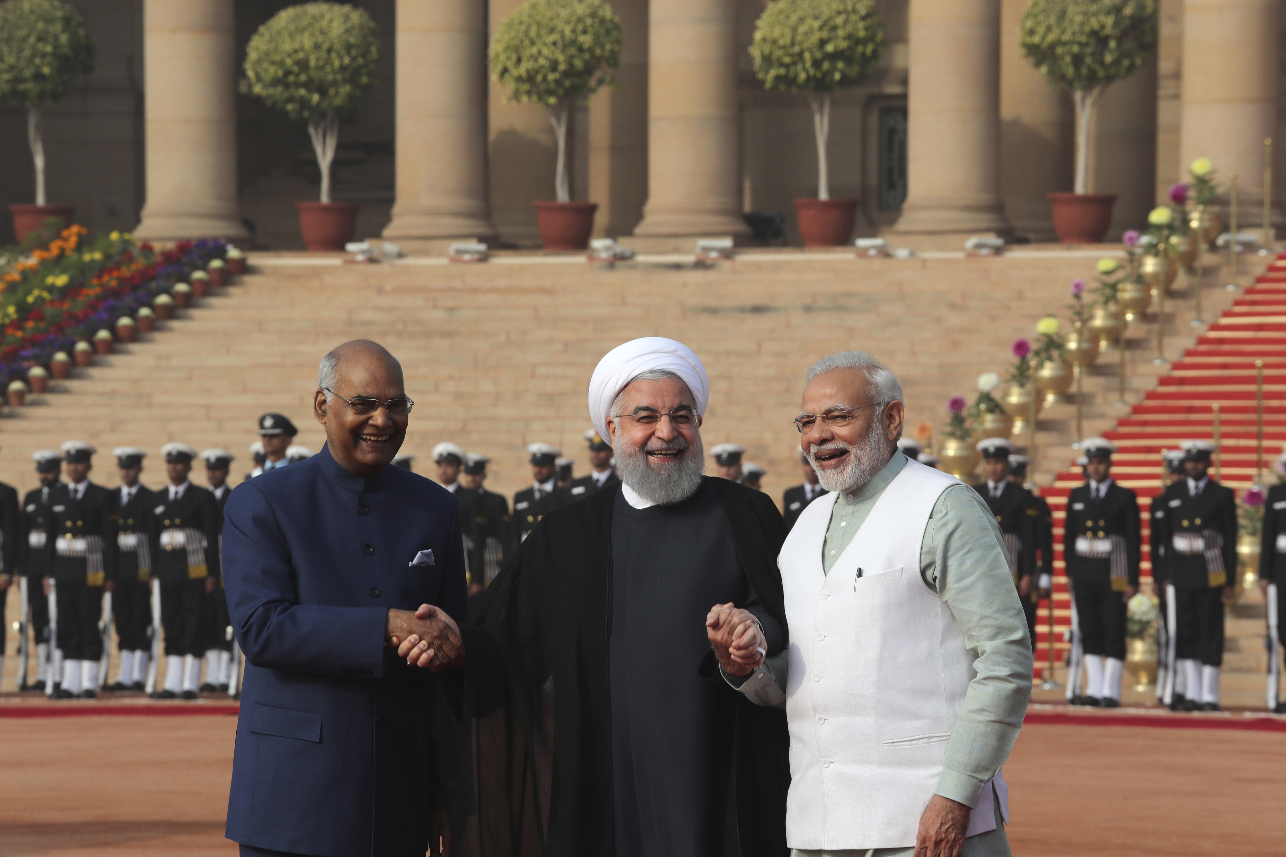 Iranian President Hassan Rouhani, center, holds hands of his Indian counterpart Ram Nath Kovind, left, and Indian Prime Minister Narendra Modi during his ceremonial reception at the Indian presidential palace, in New Delhi, India, Saturday, Feb. 17, 2018. Rouhani, who is on three days state visit to India has strongly criticized the Trump administration's recognition of Jerusalem as Israel's capital and urged Muslims to support the Palestinian cause. (AP Photo/Manish Swarup)