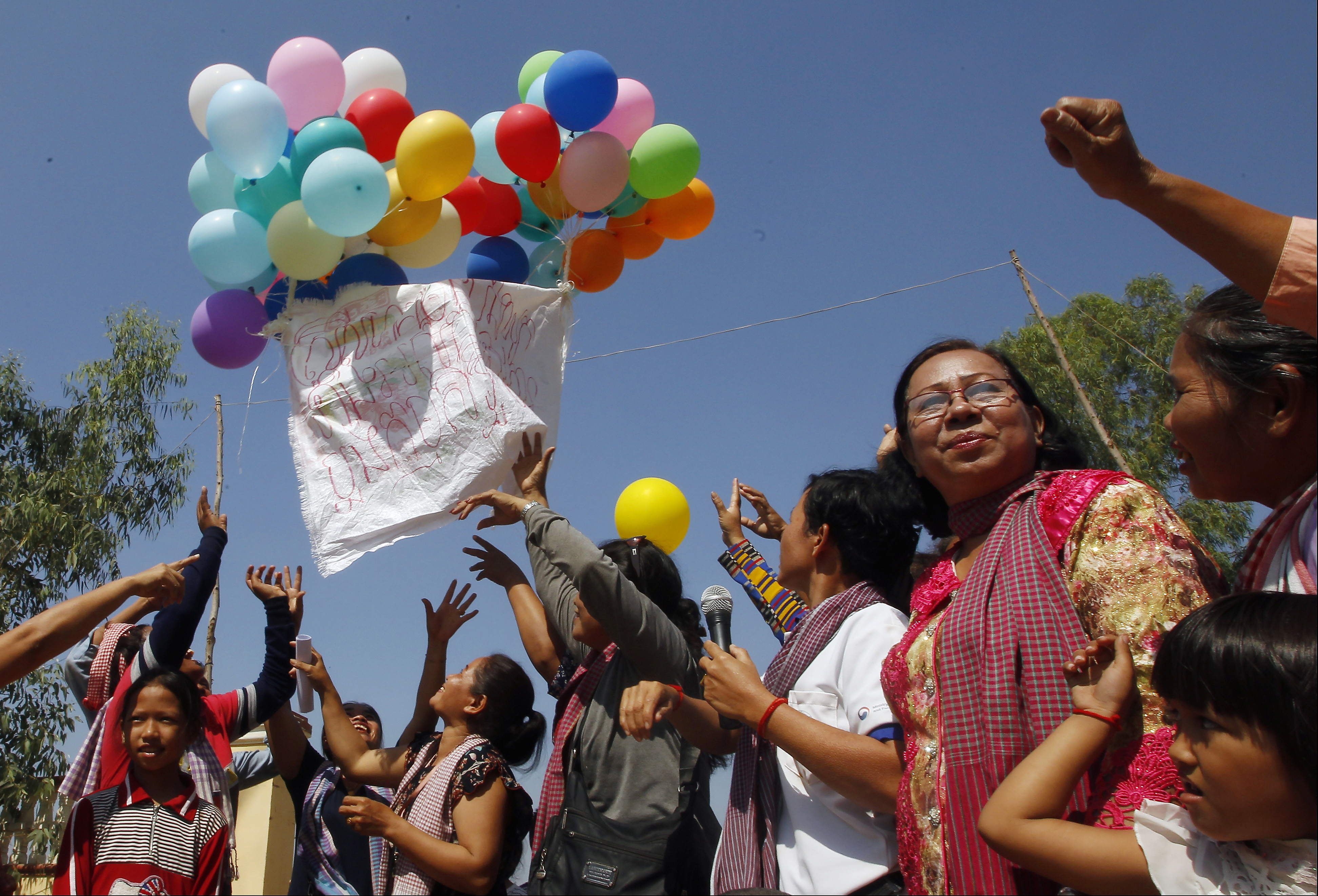 Land activists from Boeung Chhuk community release balloons to mark International Women's Day on the outskirts of Phnom Penh, Cambodia, Thursday, March 8, 2018. The community people took part in the International Women's Day celebration, coincided with the 10th anniversary of their forced eviction. (AP Photo/Heng Sinith)
