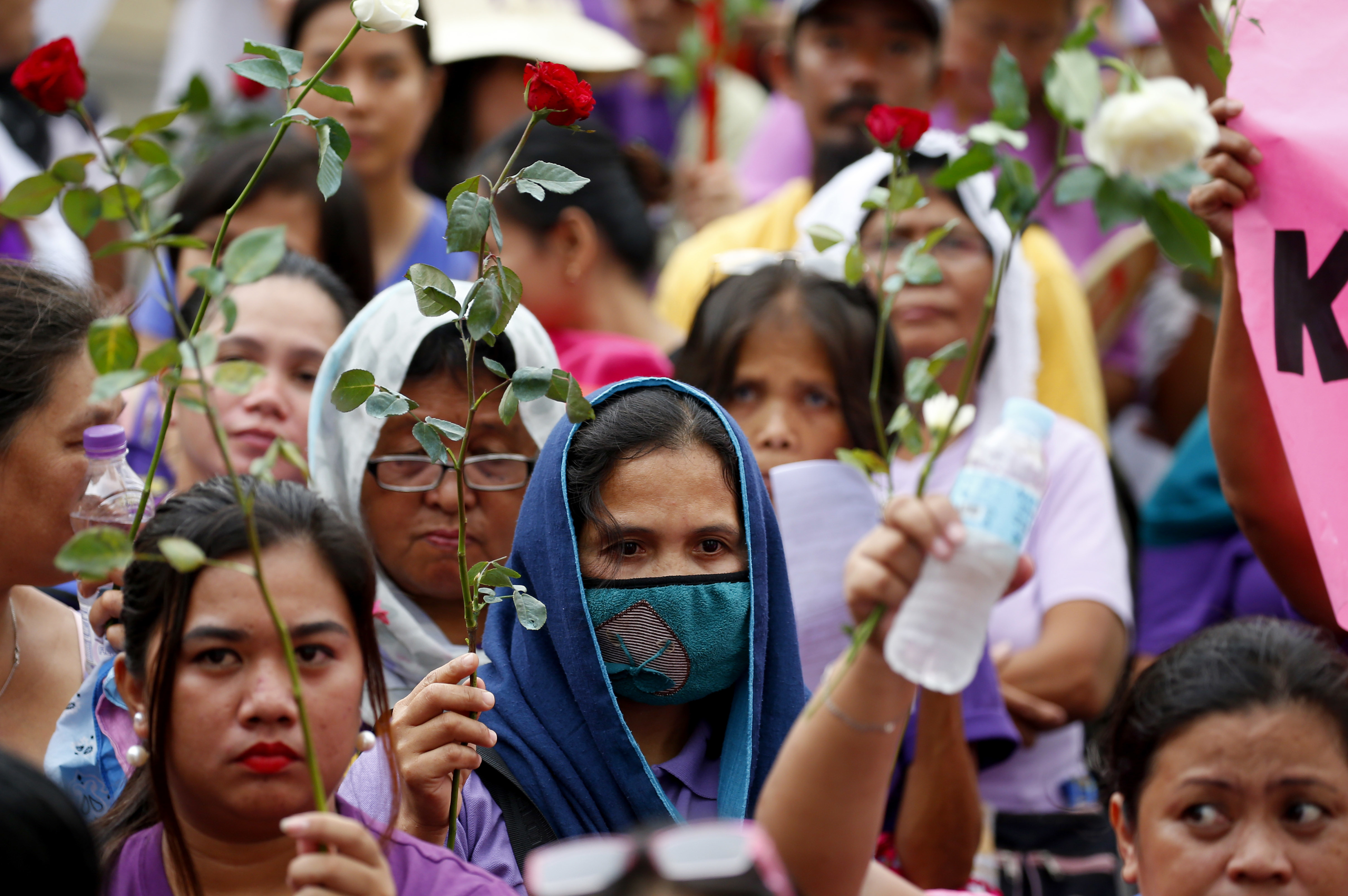 Protesters hold flowers during a rally to mark International Women's Day Thursday, March 8, 2018 in Manila, Philippines. Hundreds of women activists in pink and purple shirts protested against President Rodrigo Duterte in the Philippines on Thursday, as marches and demonstrations in Asia kicked off International Women’s Day. (AP Photo/Bullit Marquez)