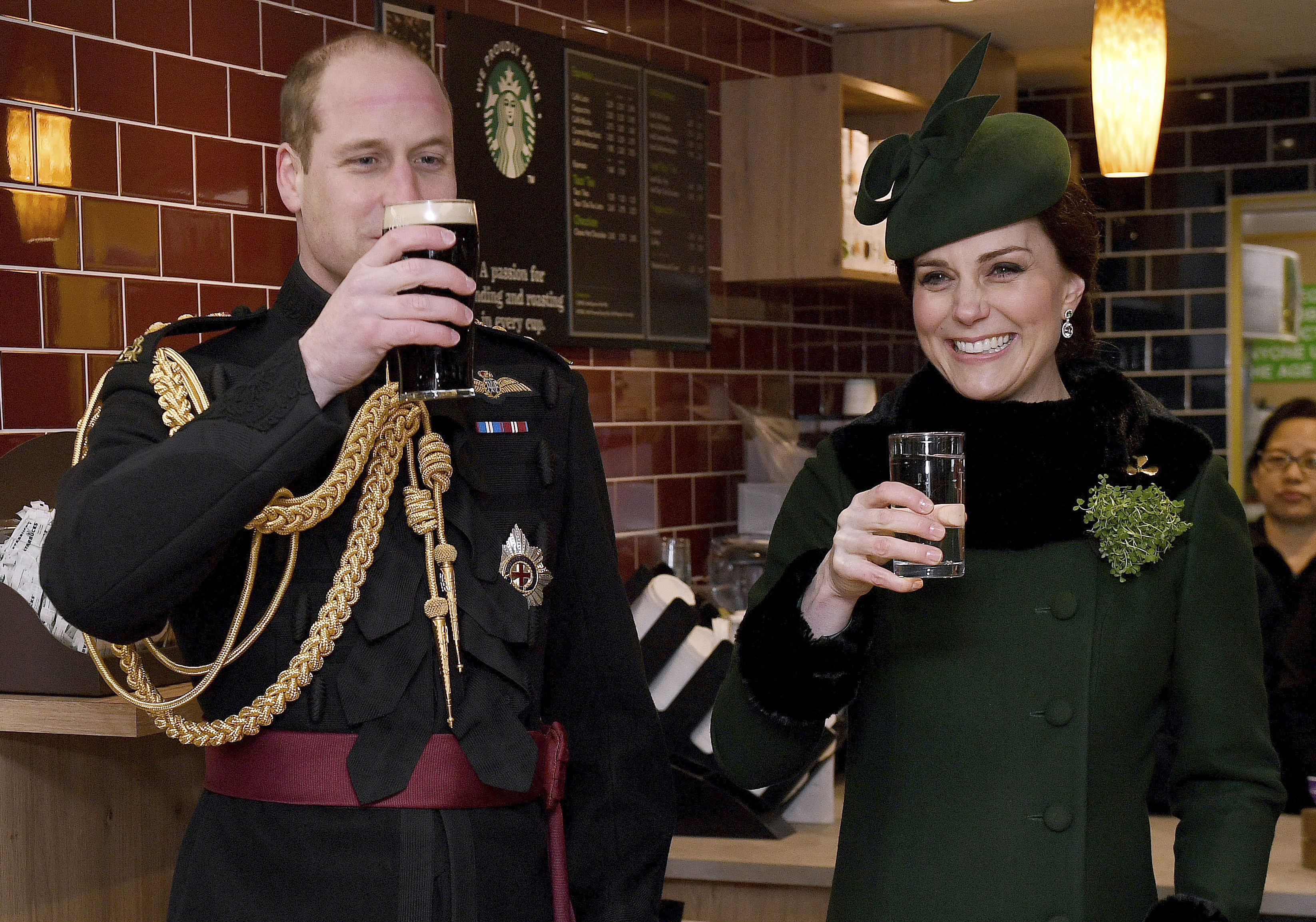 Britain's Kate, the Duchess of Cambridge, smiles as she and Prince William toast, as they visit the 1st Battalion Irish Guards, for the St. Patrick's Day Parade, at Cavalry Barracks, in Hounslow, England, Saturday, March 17, 2018.  (Andrew Parsons/Pool Photo via AP)