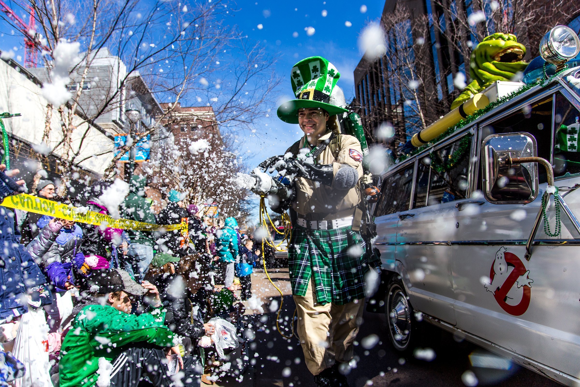 A participant dressed as a Ghostbuster in a kilt and leprechaun hat sprays the crowd with foam during the 18th annual St. Patrick's Day Parade in Kalamazoo, Mich., on Saturday, March 17, 2018. (Rebekah Welch/Kalamazoo Gazette-MLive Media Group via AP)