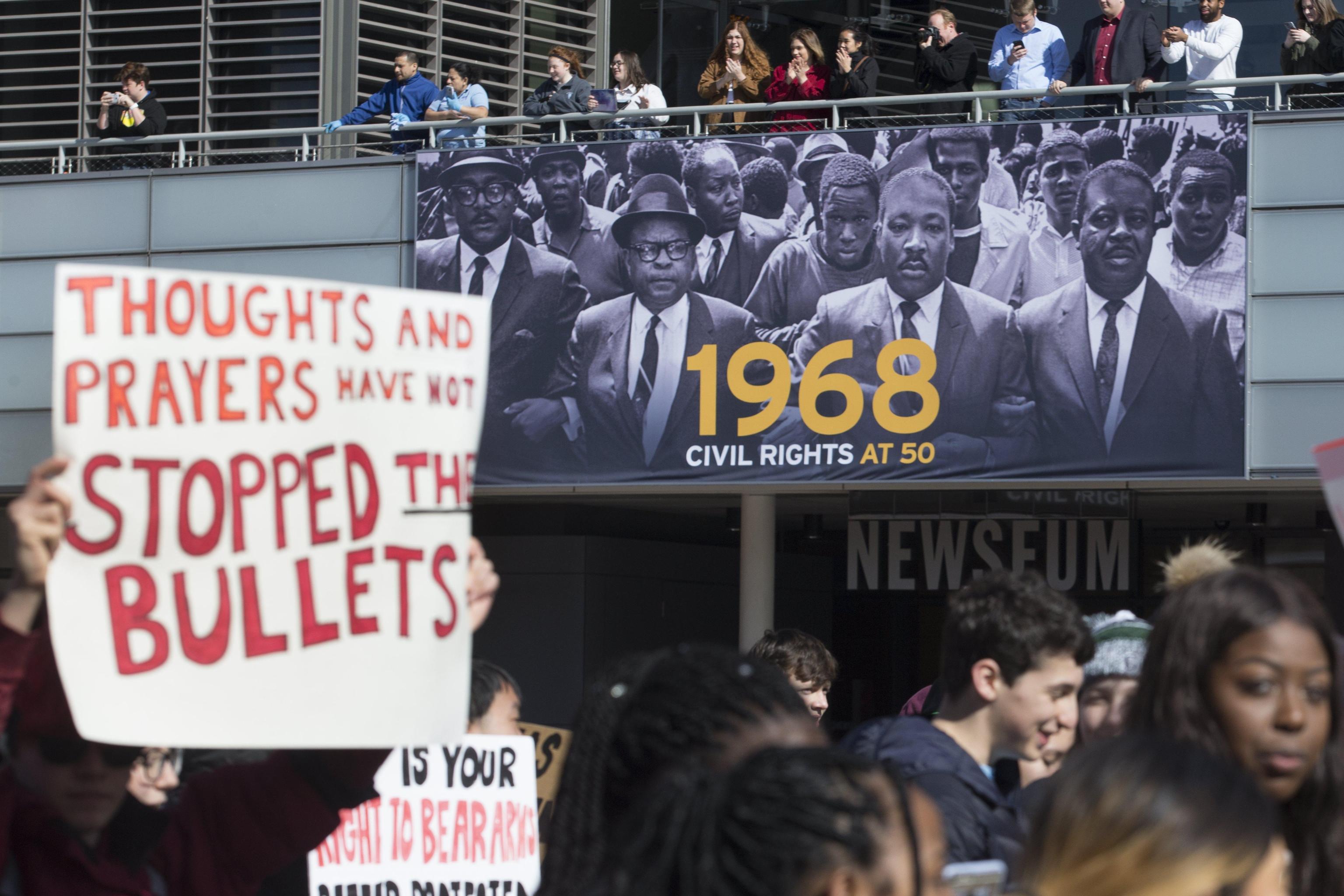 epa06604026 Young people marching in the national school walkout over gun violence pass the image of the late Dr. Martin Luther King Jr., as people cheer them on at the Newseum while the group walks from the White House to Capitol Hill, in Washington, DC, USA, 14 March 2018. Students across the United States were expected to walk out of their classes for seventeen minutes to honor the seventeen victims of the 14 February shooting at Marjory Stoneman Douglas High School in Parkland, Florida.  EPA/MICHAEL REYNOLDS
