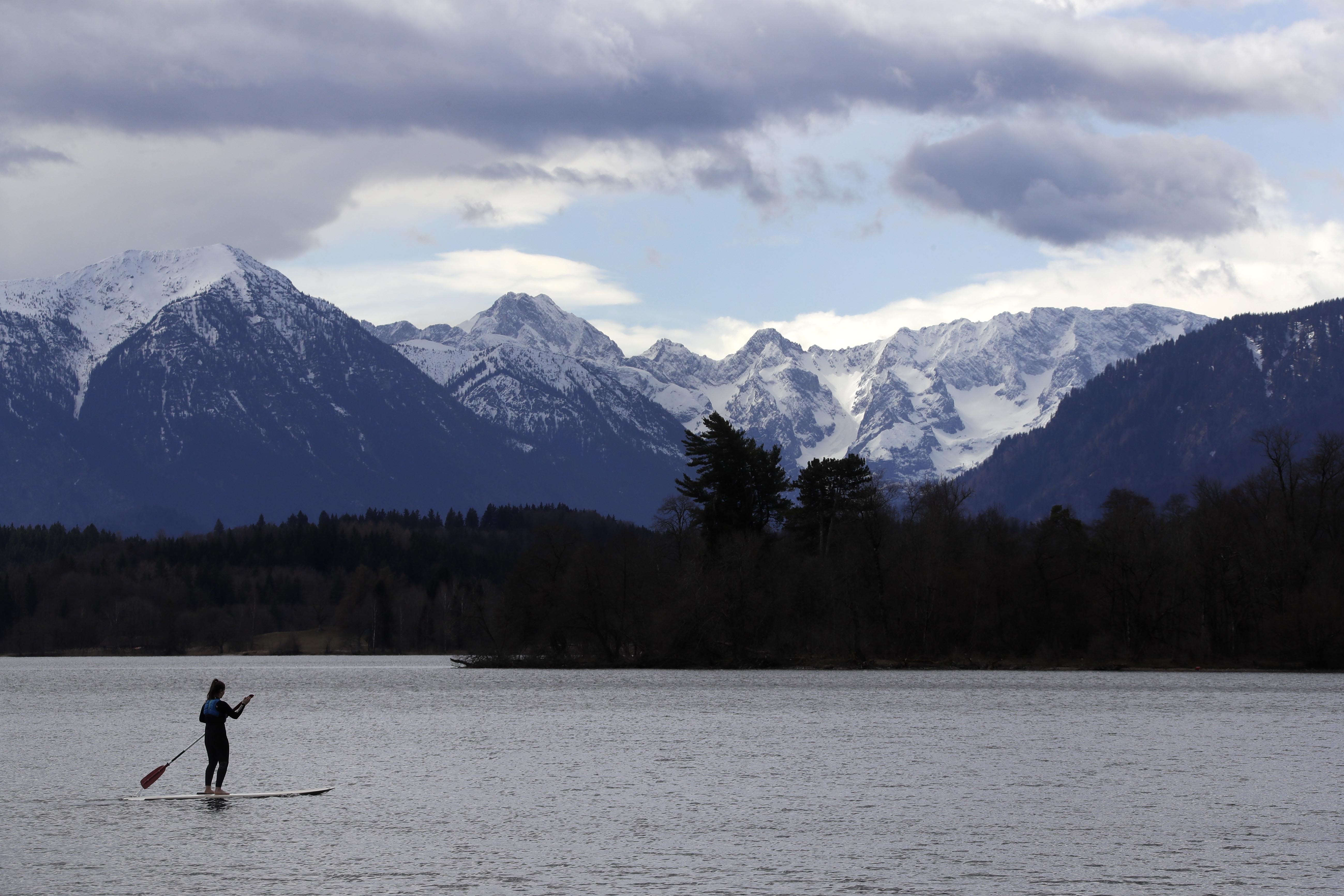 A stand-up paddler makes her way on lake Staffelsee in front of the Alps in Uffing near Garmisch-Partenkirchen, Germany, Thursday, April 5, 2018. (AP Photo/Matthias Schrader)