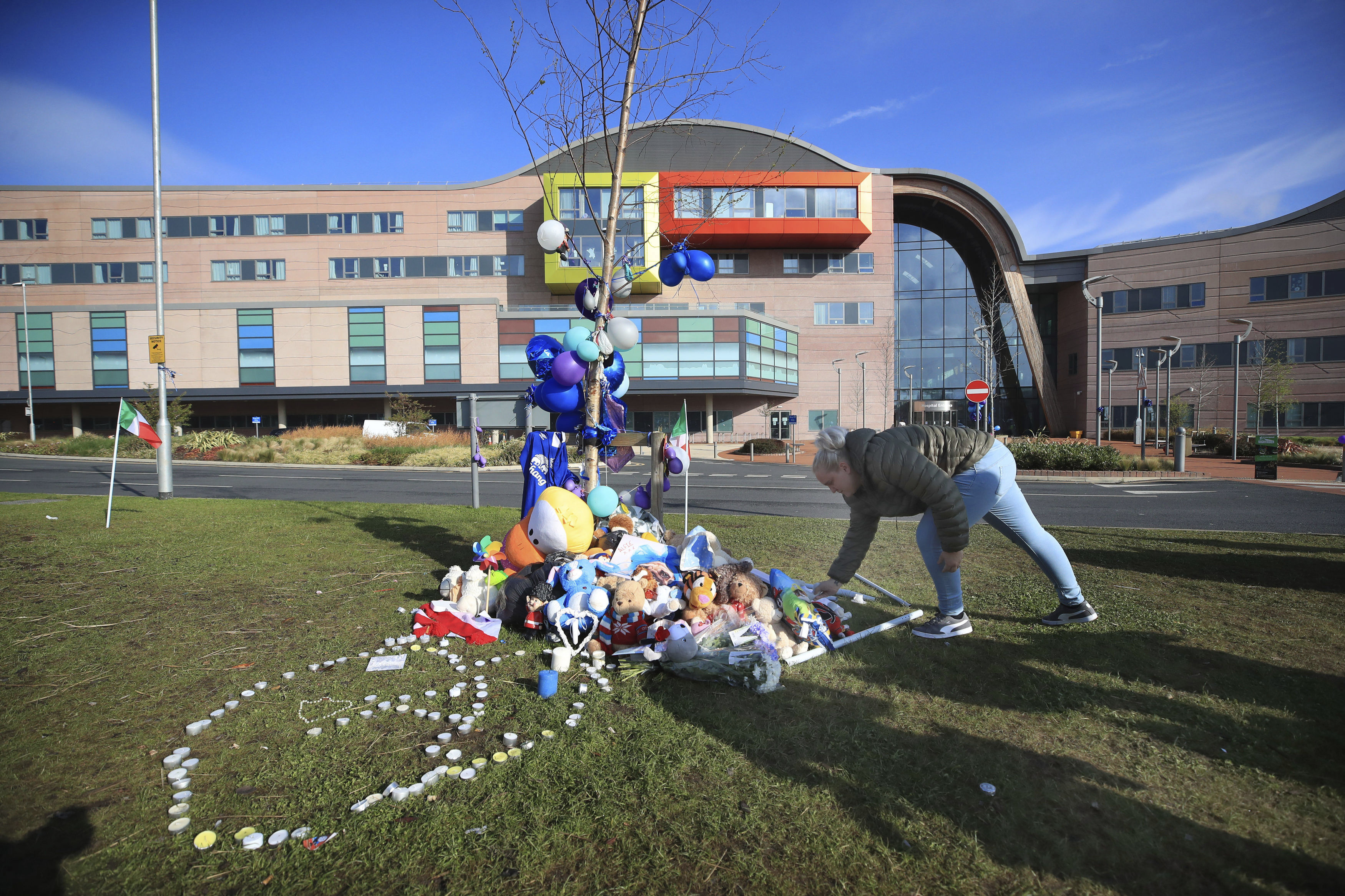 A woman leaves a soft toy outside Alder Hey Children's Hospital in Liverpool, England, following the death of 23-month-old, Alfie Evans, Saturday April 28, 2018. Alfie Evans, the sick British toddler whose parents won support from Pope Francis during a protracted legal battle over his treatment, died early Saturday. He was 23 months old. (Peter Byrne/PA via AP)