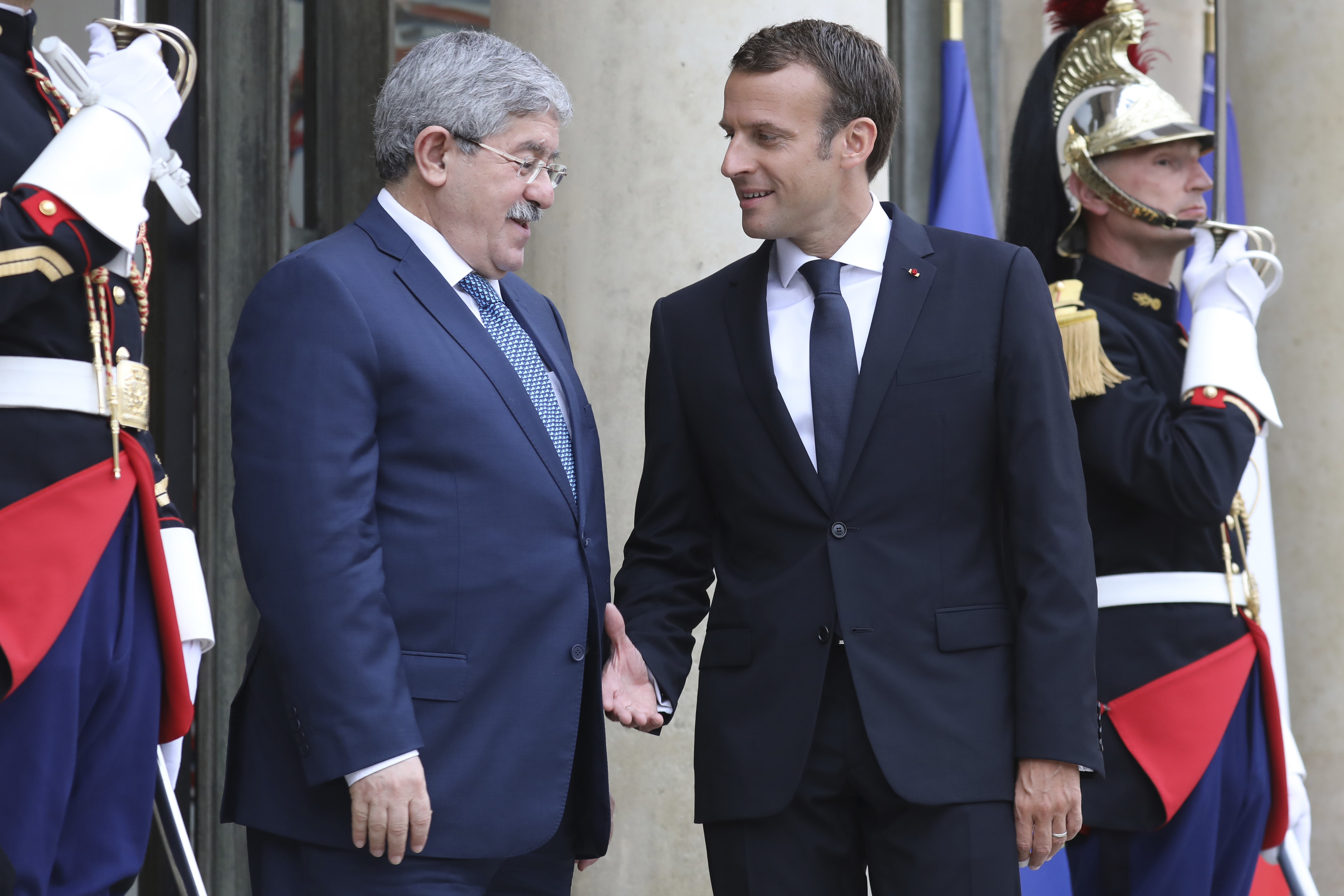 French president Emmanuel Macron, right, welcomes Algerian Prime Minister Ahmed Ouyahia in Paris,Tuesday May 29, 2018. Libya's rival leaders are meeting in Paris to agree on a political roadmap including elections, in an effort to bring order to Libya's chaos, which is feeding Islamic militants, traffics of all kind and instability in the region. (Ludovic Marin, Pool via AP)