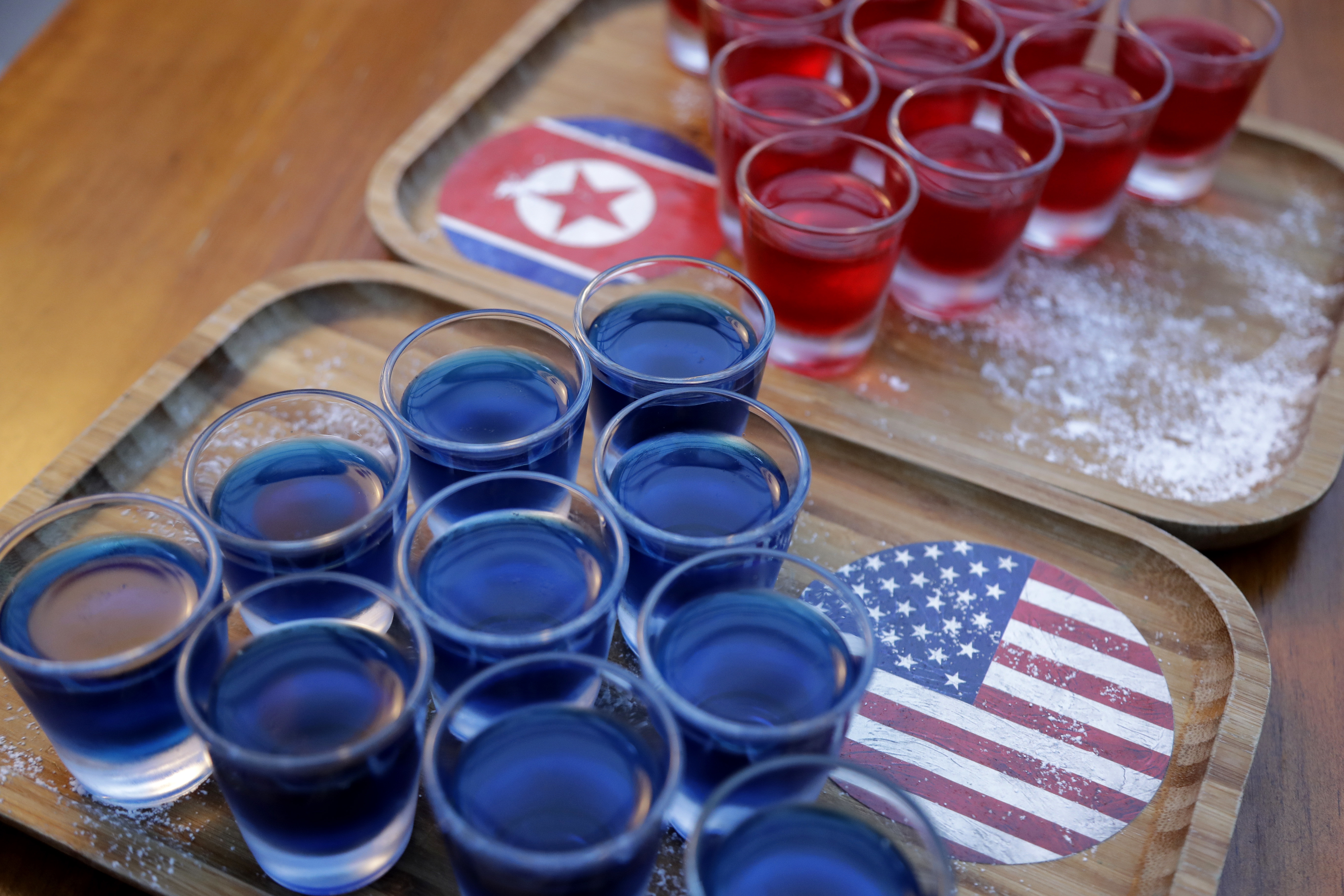In this June 7, 2018, photo, alcoholic drinks inspired by the upcoming summit between U.S. President Donald Trump and North Korean leader Kim Jong Un is displayed at a local bar, the Escobar, in Singapore. Singapore is a city that takes great pride in its food, so it’s not surprising that enterprising restaurateurs are using next week’s historic summit between U.S. President Donald Trump and North Korean leader Kim Jong Un to showcase some culinary creativity. Restaurants are marking the city-state’s time in the global spotlight with everything from red, white and blue cocktails to tacos named after the two leaders.  (AP Photo/Wong Maye-E)