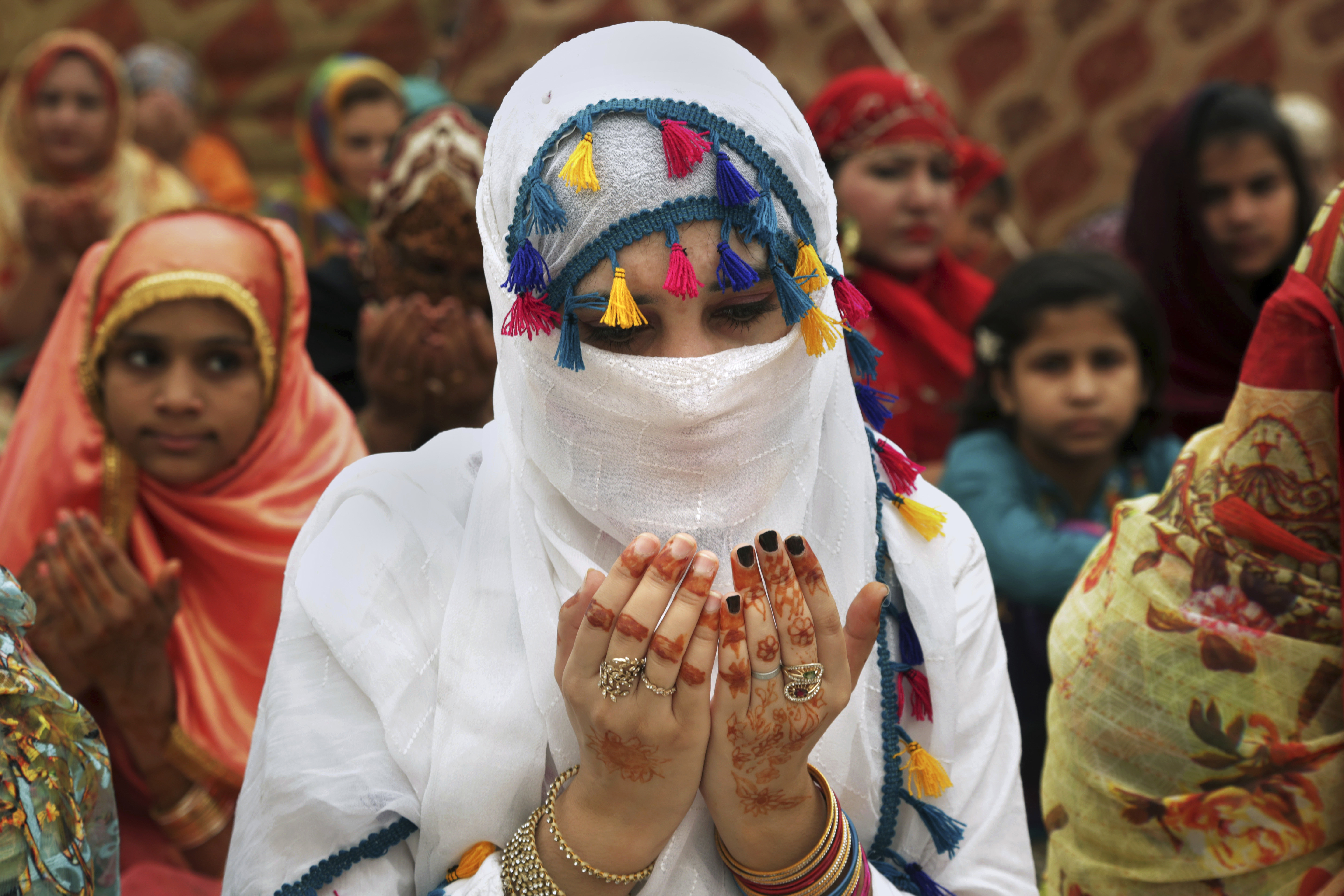 A woman prays after offering Eid al-Fitr prayers to celebrate the end of the holy month of Ramadan, at a historical Badshahi mosque in Lahore, Pakistan, Saturday, June 16, 2018. (AP Photo/K.M. Chaudary)