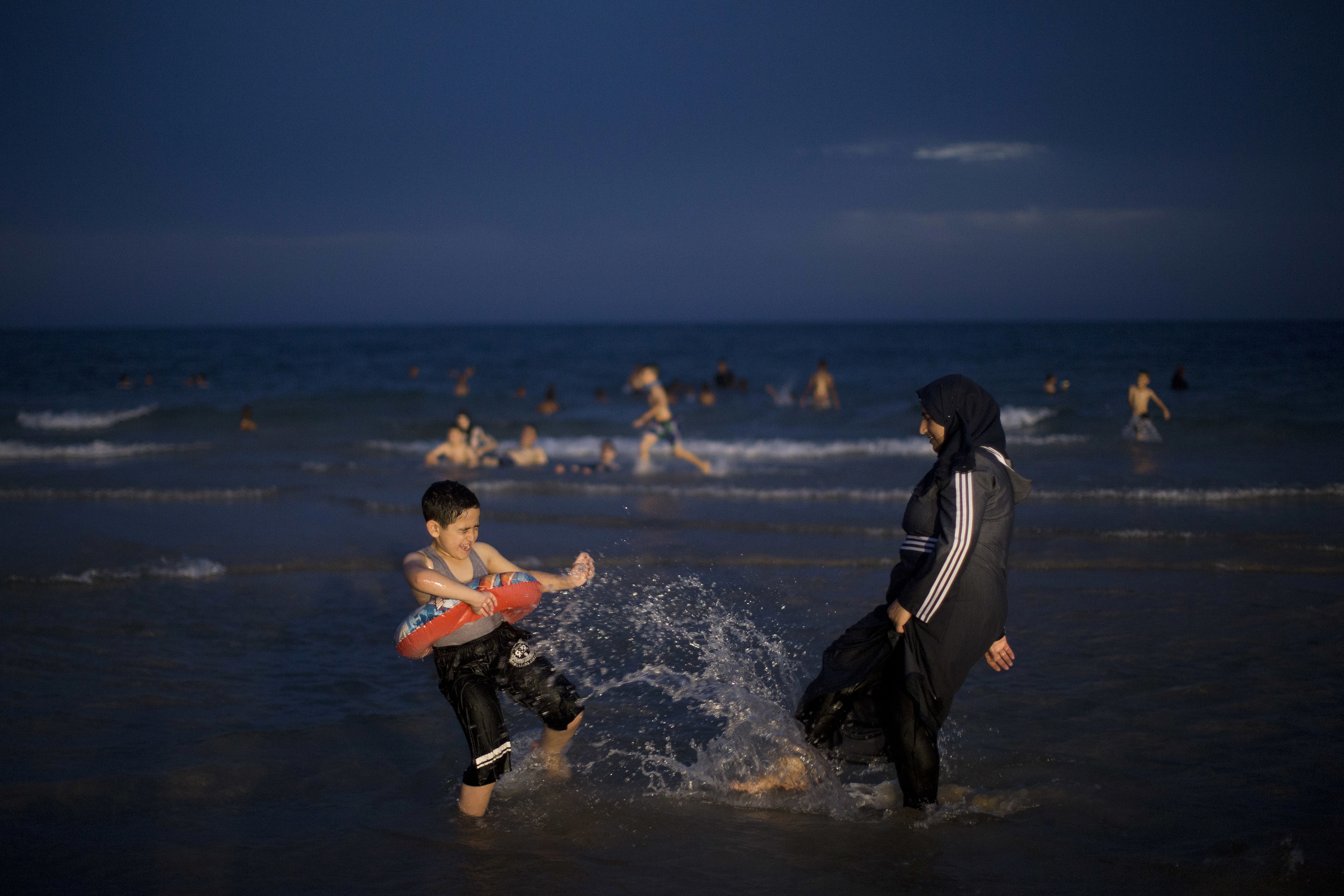 Palestinians spend the day on the beach during the Muslim Eid al-Fitr holiday in Tel Aviv, Israel, Saturday, June 16, 2018. Eid al-Fitr marks the end of the fasting month of Ramadan. (AP Photo/Oded Balilty)
