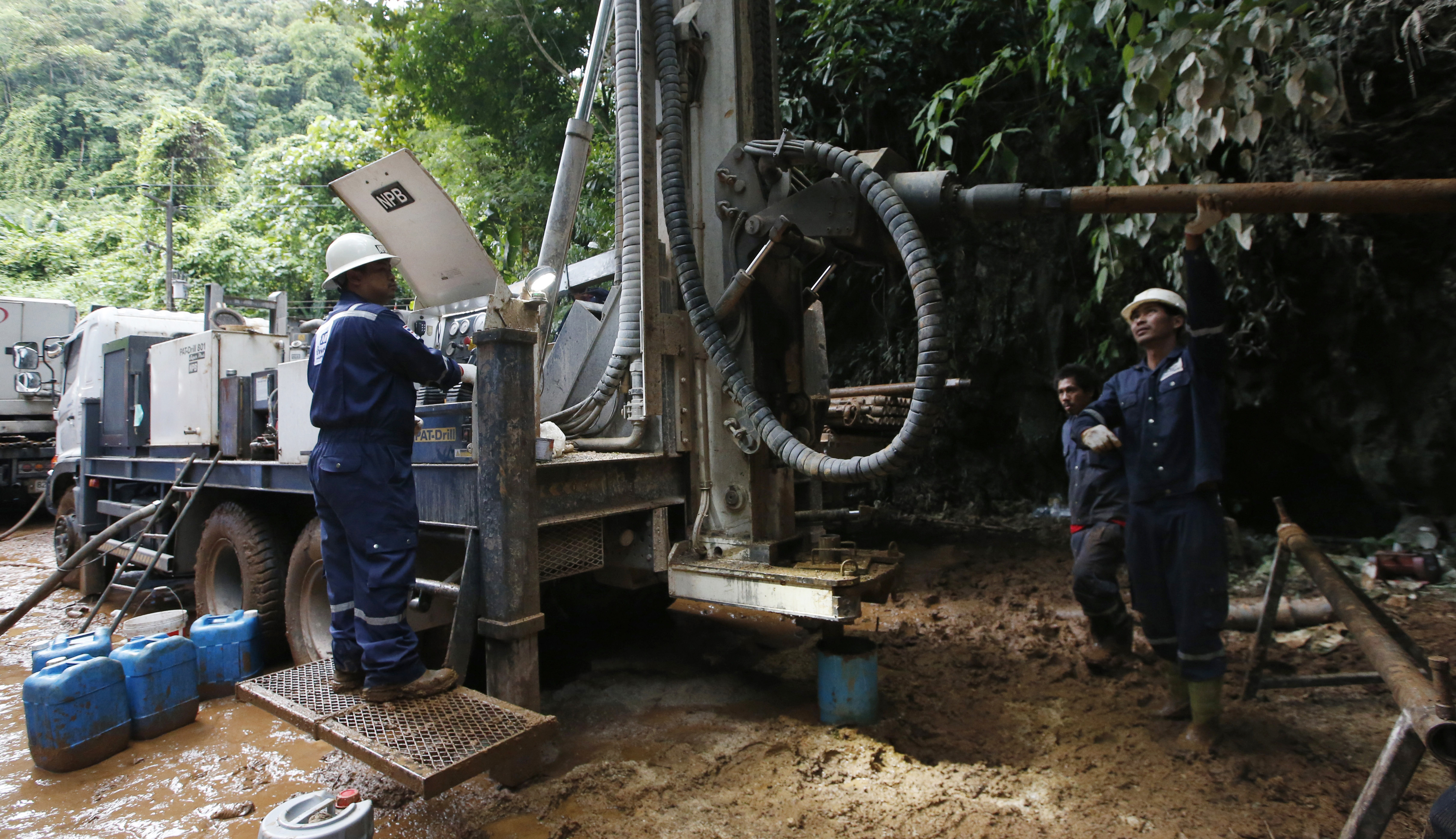 Workers operate a machinery in attempts to drain the water from a cave where 12 boys and their soccer coach have been missing, in Mae Sai, Chiang Rai province in northern Thailand, Friday, June 29, 2018. Floodwaters have reached near the entrance of the cave despite attempts to drain the water so rescuers can search farther into the complex. (AP Photo/Sakchai Lalit)