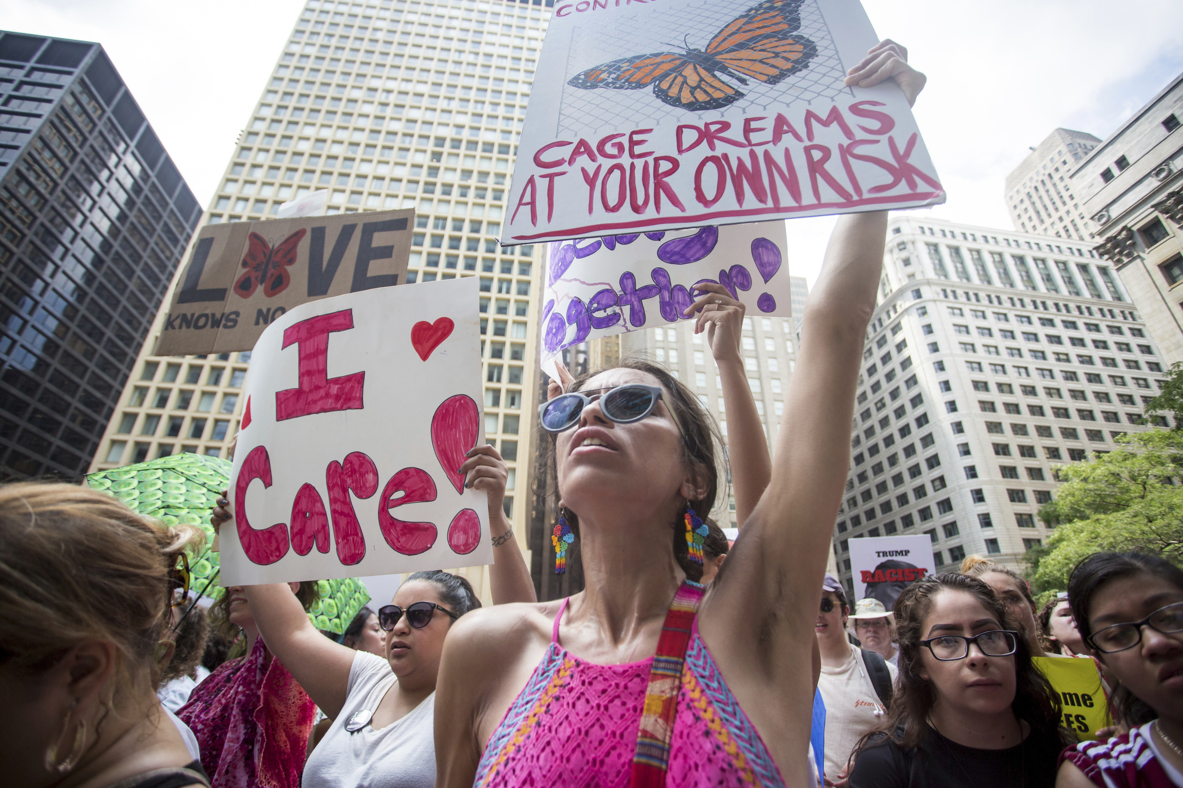 People hold signs as they participate in the Families Belong Together march in Chicago on Saturday, June 30, 2018. In major cities and tiny towns, marchers gathered across America, moved by accounts of children separated from their parents at the U.S.-Mexico border, in the latest act of mass resistance against President Donald Trump's immigration policies. (James Foster/Chicago Sun-Times via AP)