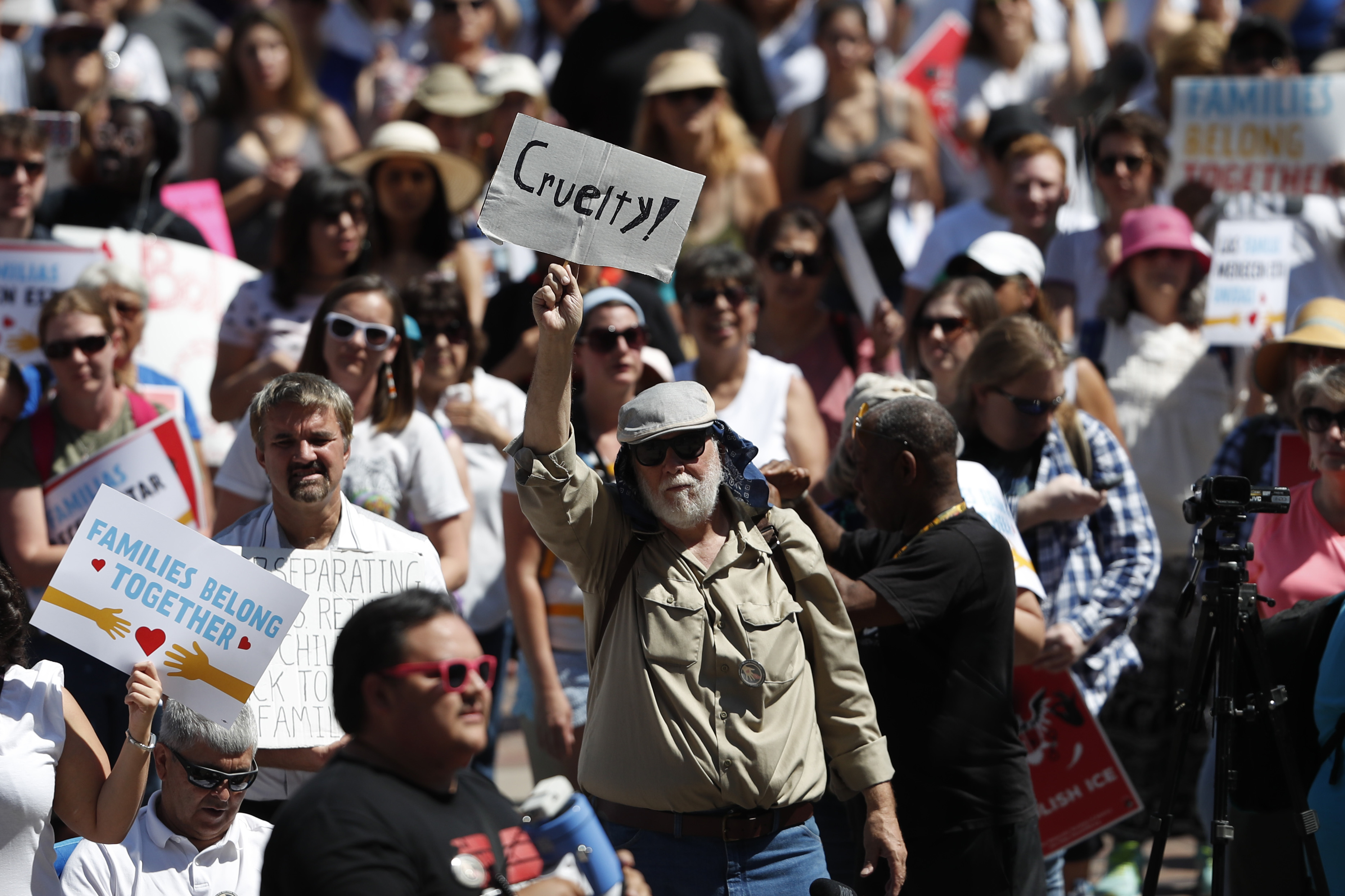 A protester holds up a one-word placard--Cruelty--during an immigration rally and protest in Civic Center Park Saturday, June 30, 2018, in downtown Denver. The protest was one of hundreds staged nationwide that has brought liberal activists, parents and first-time protesters--motivated by accounts of children separated from their parents at the US-Mexico border--to press President Donald Trump to reunite families quickly. (AP Photo/David Zalubowski)