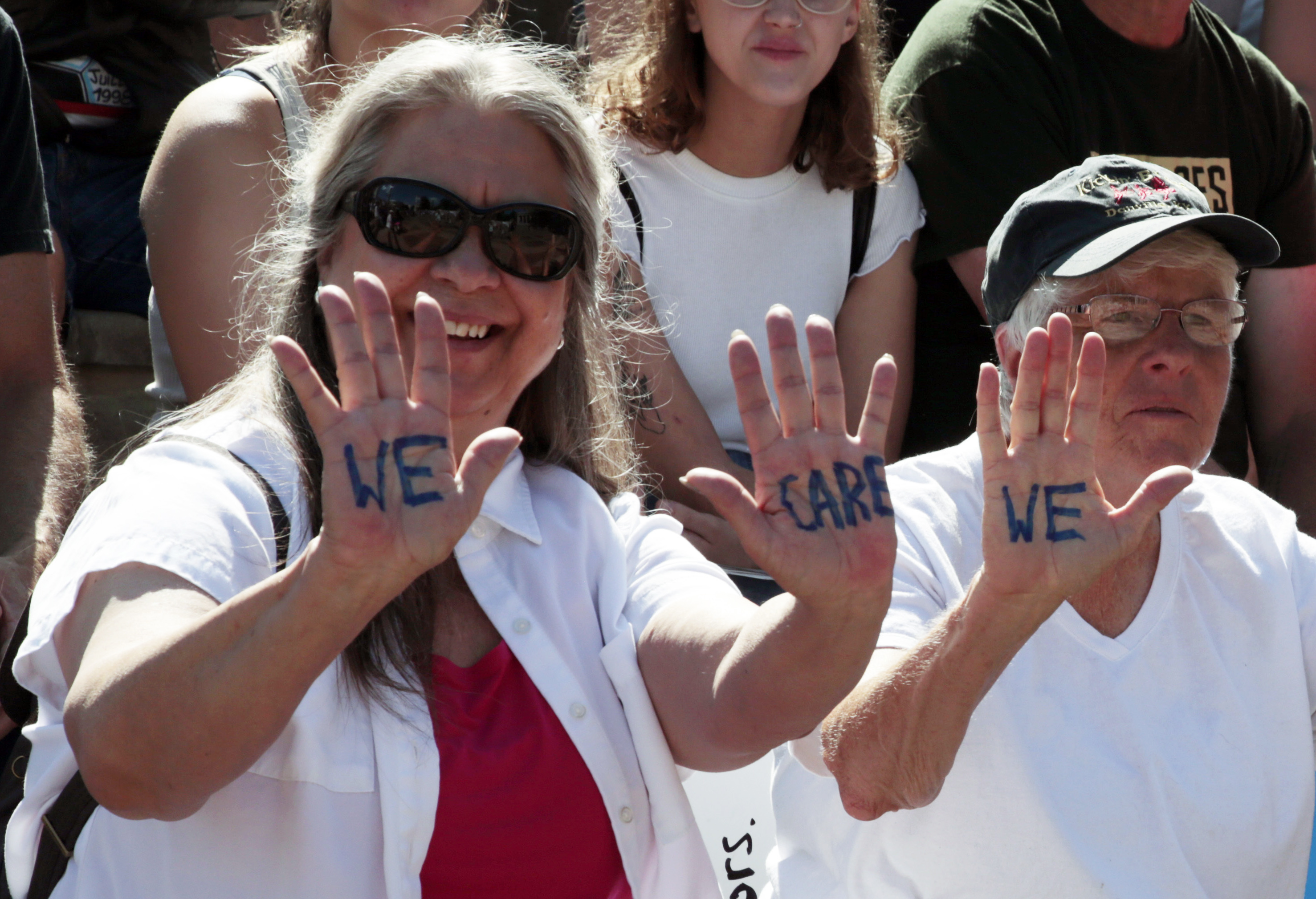 Two women hold up their hands in protest during an immigration rally and protest in Civic Center Park Saturday, June 30, 2018, in downtown Denver. The protest was one of hundreds staged nationwide that has brought liberal activists, parents and first-time protesters--motivated by accounts of children separated from their parents at the US-Mexico border--to press President Donald Trump to reunite families quickly. (AP Photo/David Zalubowski)