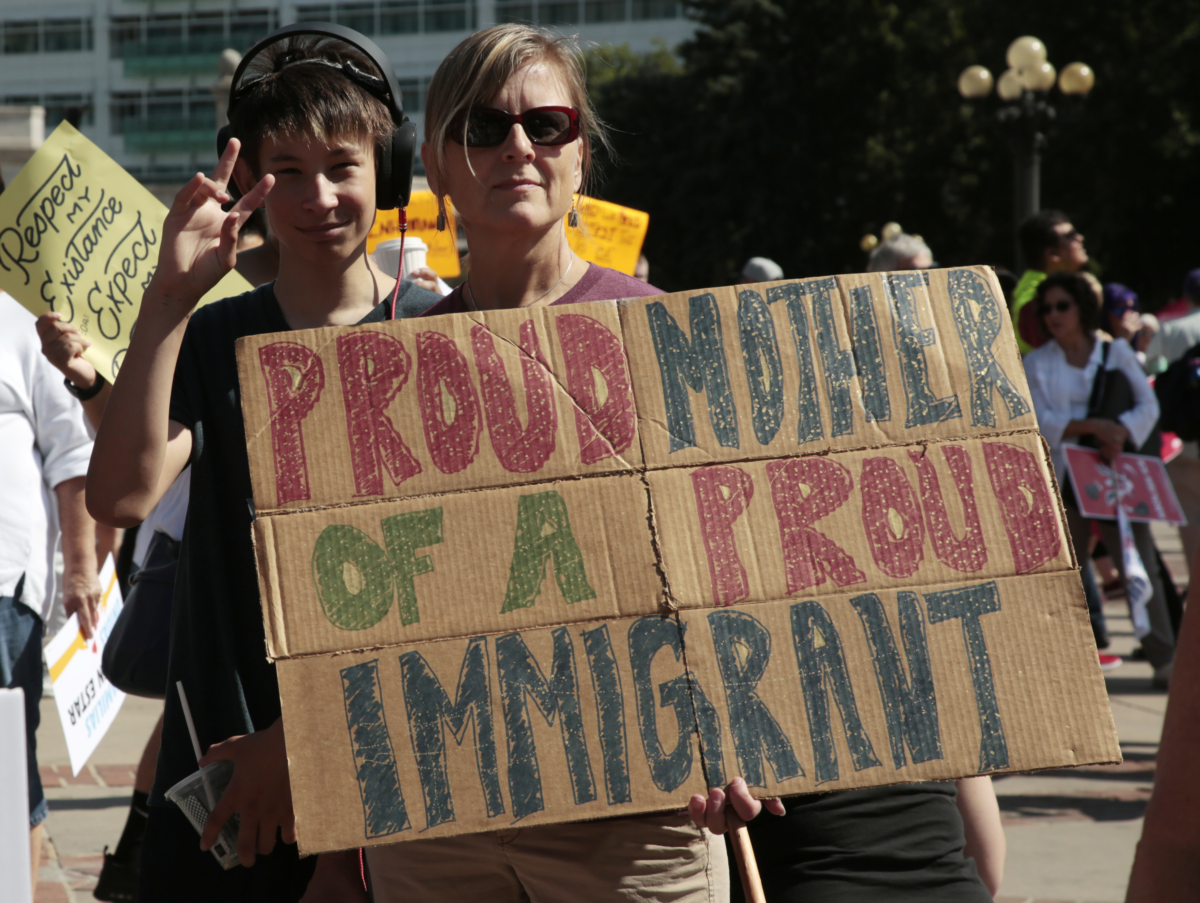 Linda Land-Classon, right, holds up a sign with her 15-year-old son, Ivan, who came to America in 2003 from Vladivostok, Russia, during an immigration rally and protest in Civic Center Park Saturday, June 30, 2018, in downtown Denver. The protest was one of hundreds staged nationwide that has brought liberal activists, parents and first-time protesters--motivated by accounts of children separated from their parents at the US-Mexico border--to press President Donald Trump to reunite families quickly. (AP Photo/David Zalubowski)