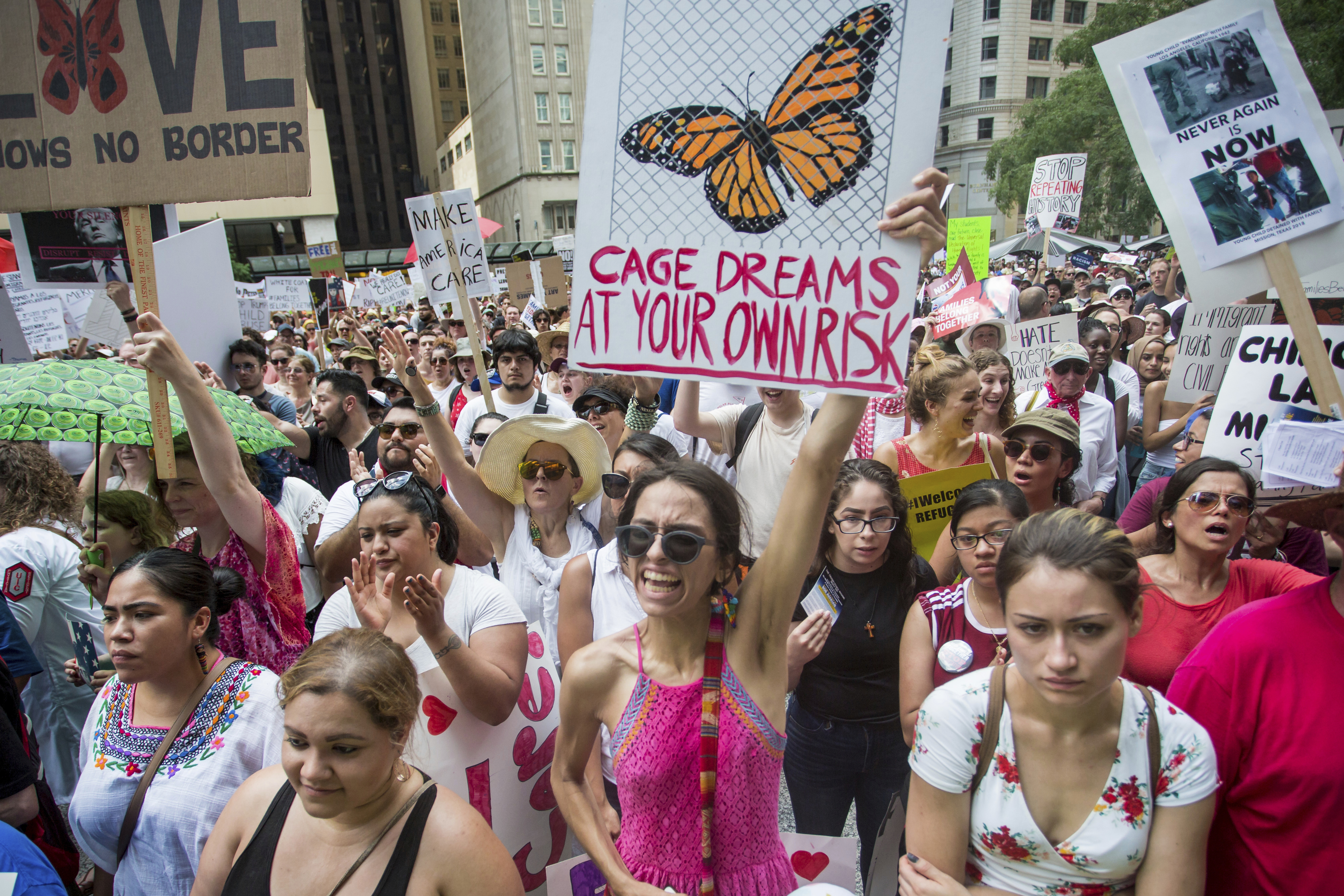 People hold signs as they participate in the Families Belong Together march in Chicago on Saturday, June 30, 2018. In major cities and tiny towns, marchers gathered across America, moved by accounts of children separated from their parents at the U.S.-Mexico border, in the latest act of mass resistance against President Donald Trump's immigration policies. (James Foster/Chicago Sun-Times via AP)